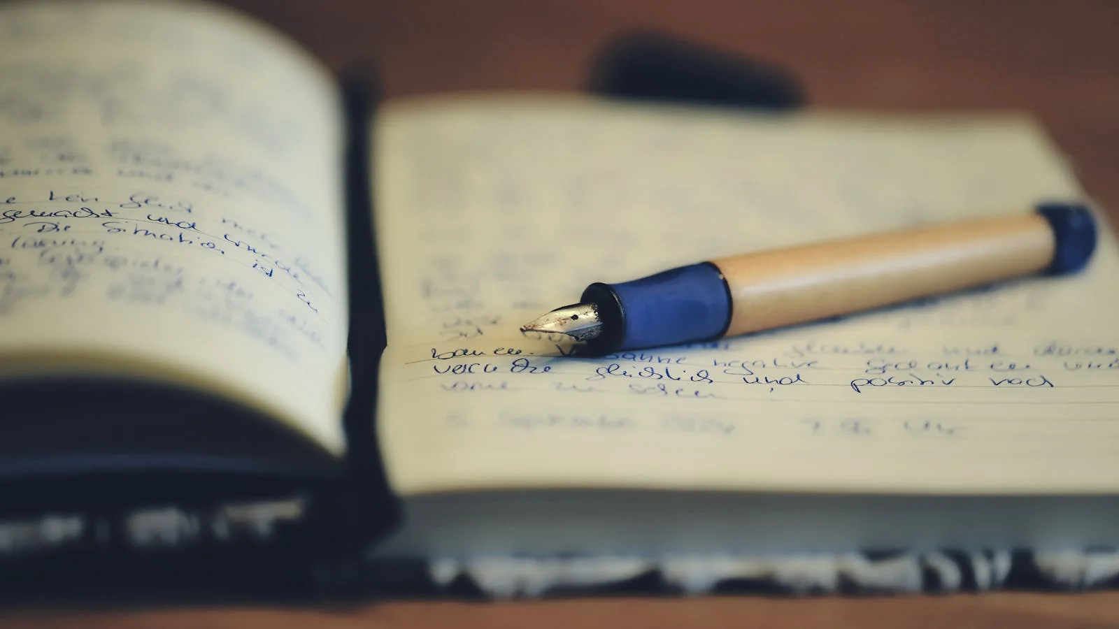 A neat fountain pen resting on the top page of a freshly written manuscript, the page filled with handwritten notes ready for an editor's review.