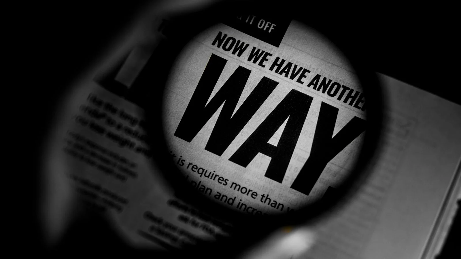 Newspaper text magnified through a lens, the earned coverage that builds a brand's citation authority