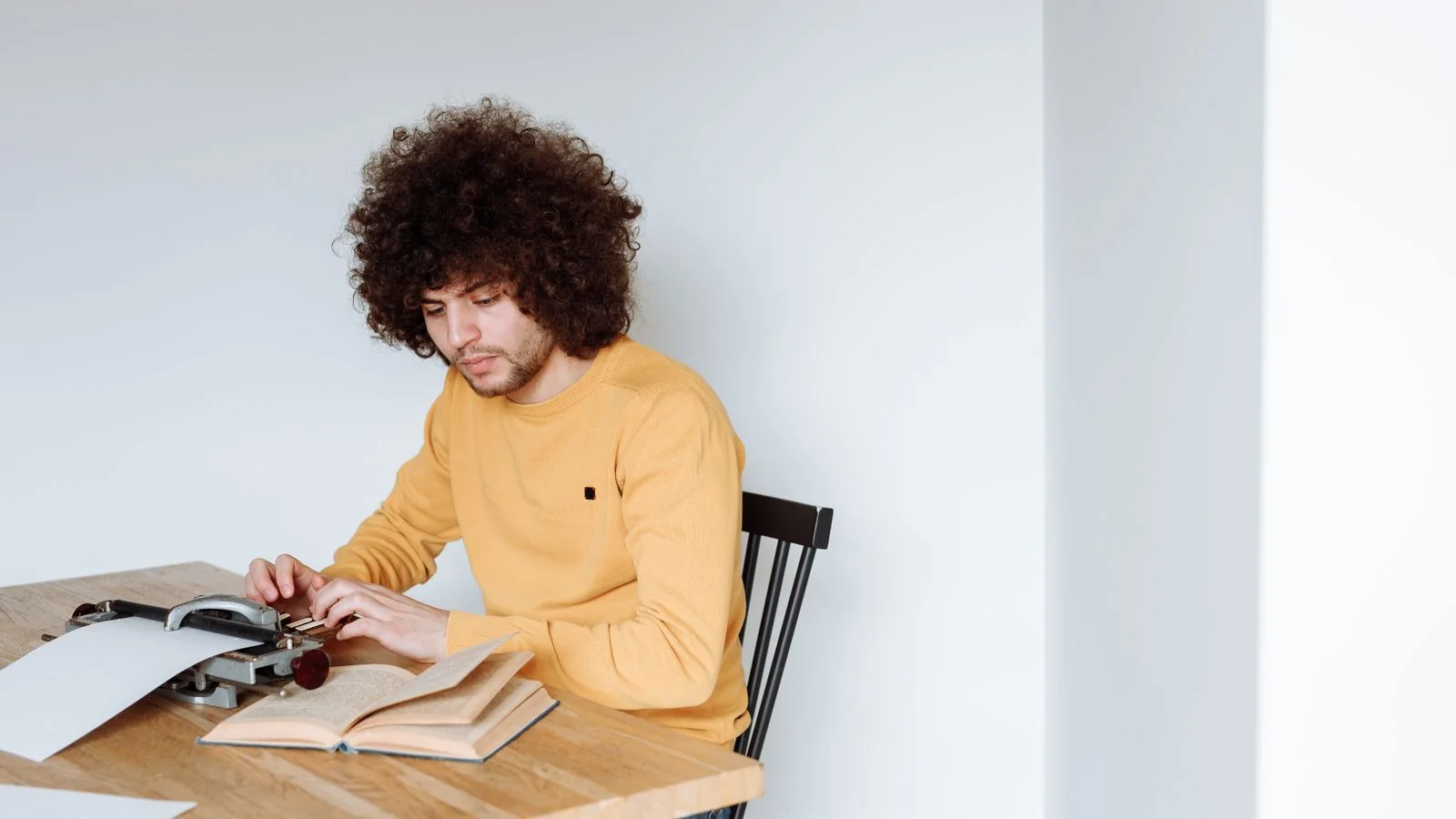 A person typing at a vintage typewriter, the focused content work that answers one sub-question of the fan-out cleanly