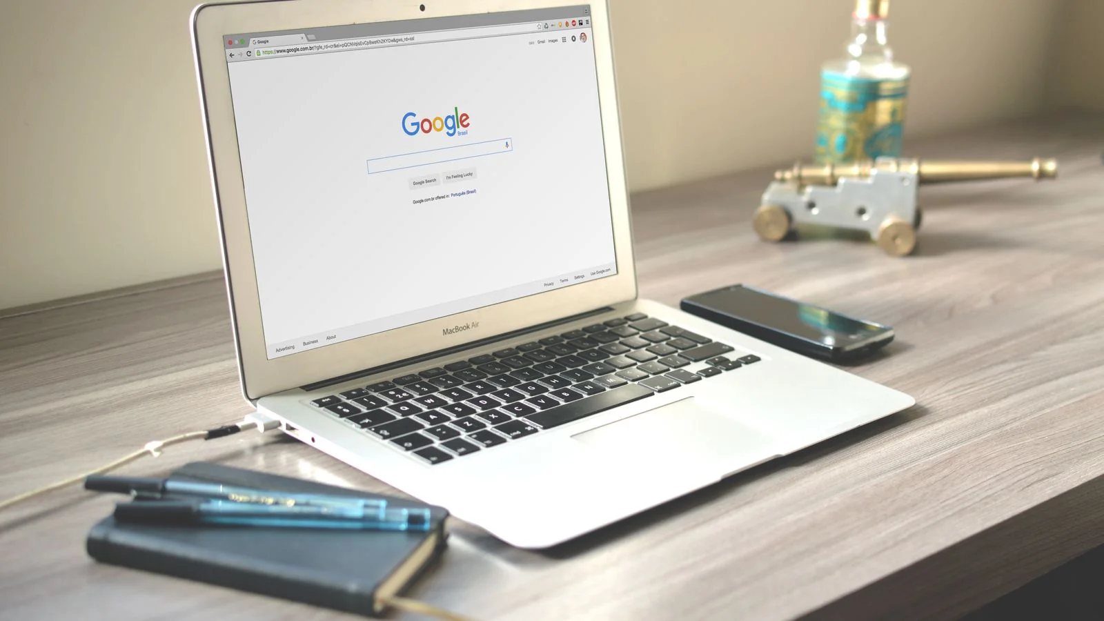 A tidy desk with a laptop showing a Google search, a phone, and a notebook, the workspace behind an optimized page