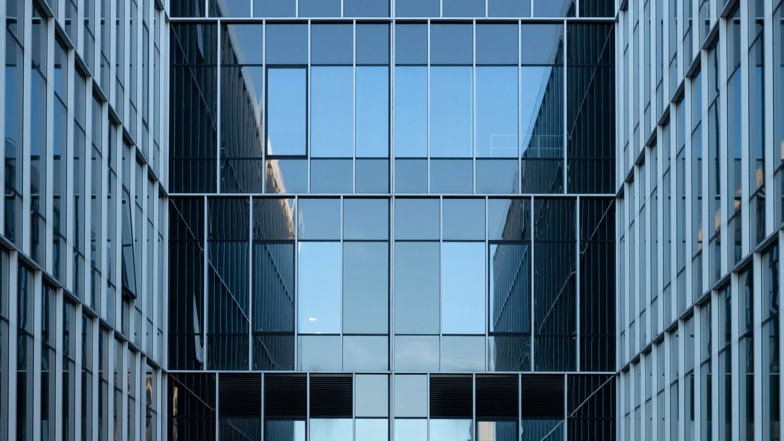 A modern glass office building, representing the enterprise environment where Copilot reaches users through Microsoft 365
