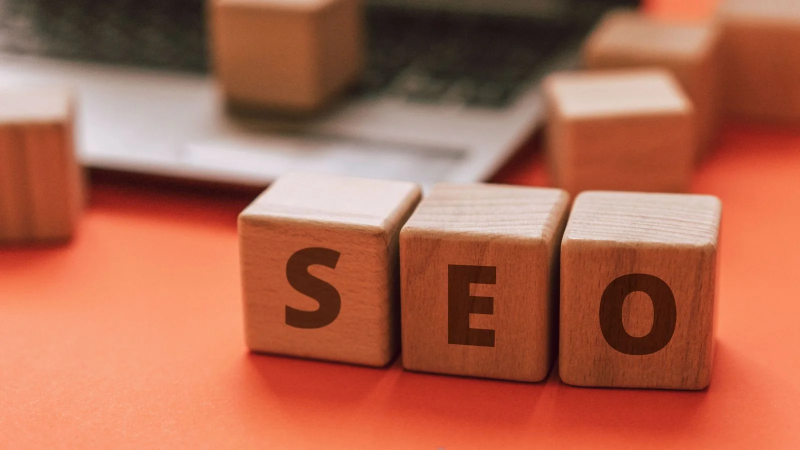 Wooden blocks spelling SEO on a laptop keyboard, the discoverability groundwork that makes a page retrievable by SearchGPT