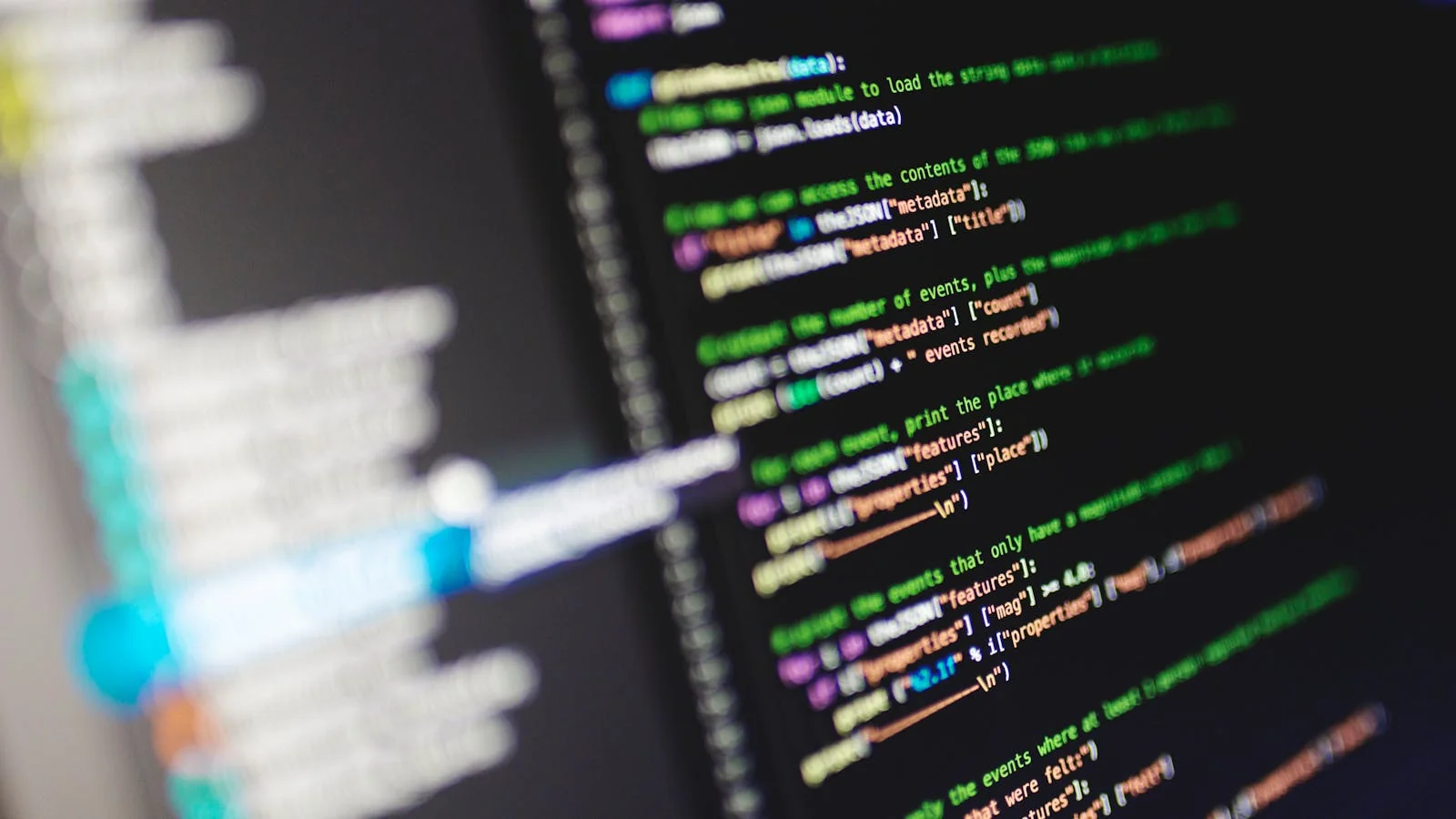 A monitor showing colorful programming code, a stand-in for the structured-data work that determines whether a brand is legible to Gemini's retrieval pipeline.