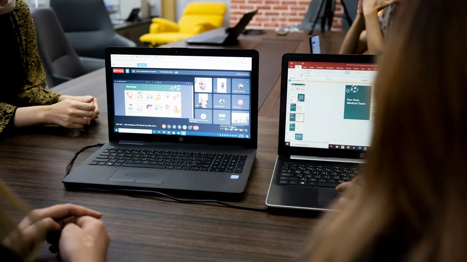 Team members reviewing work together in a hybrid meeting with a screen showing remote colleagues