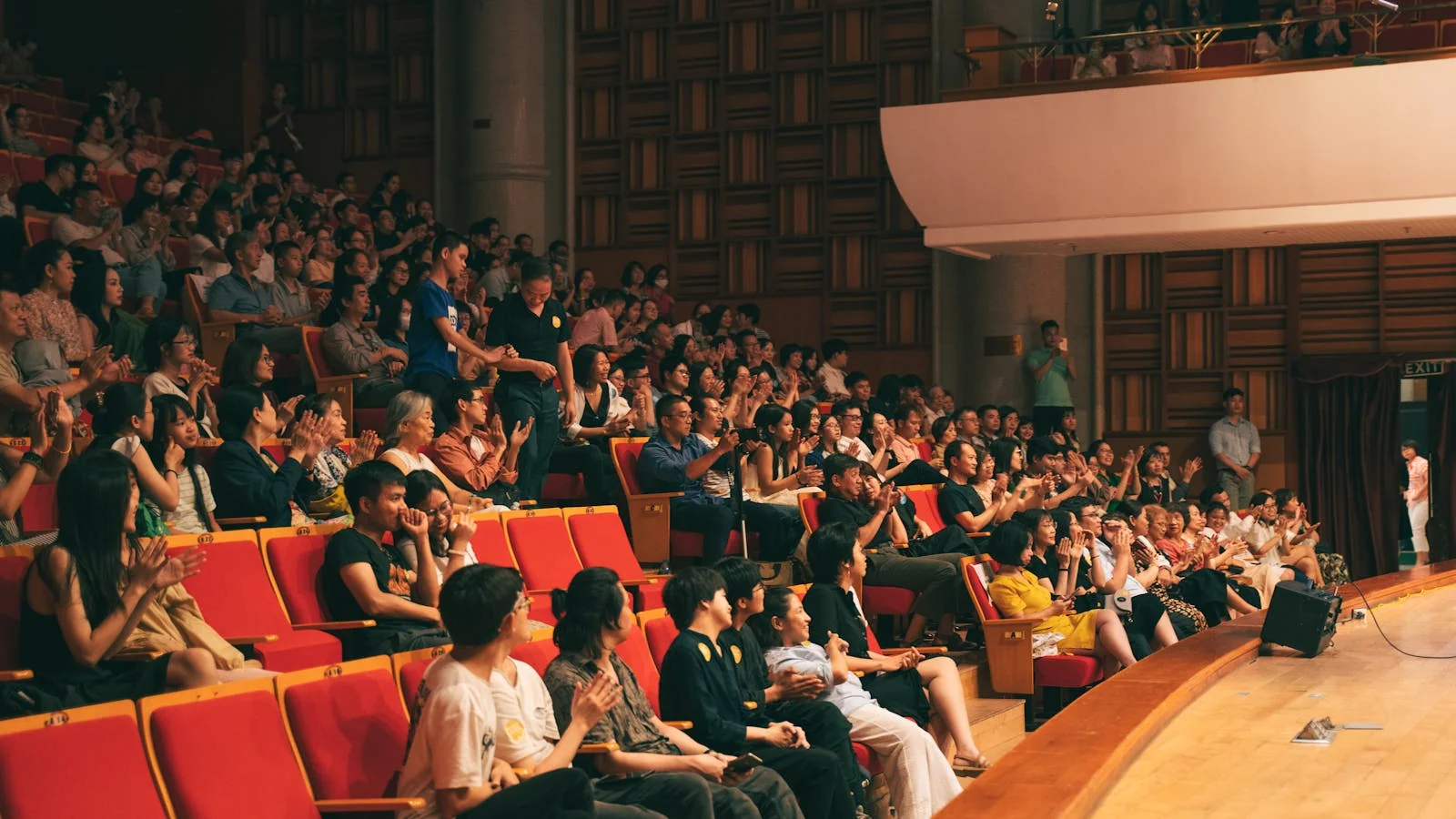 A live audience applauding under stage lights, the moment between when an award is announced and when the citation window opens.