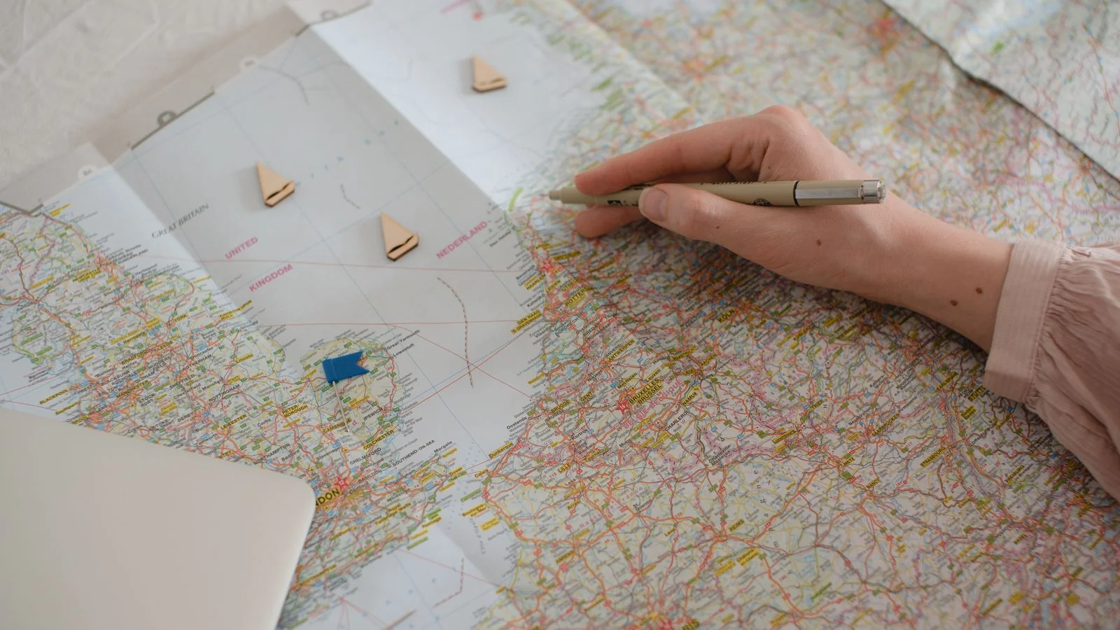 A hand marking locations on a regional map, the work of tailoring a story to each specific market