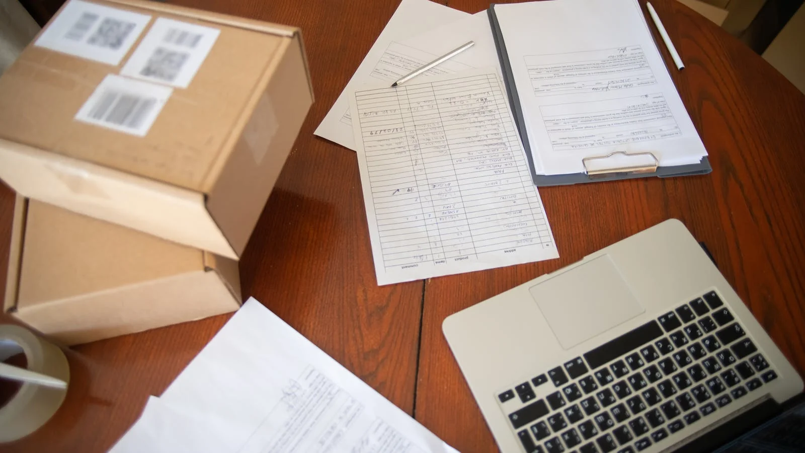 Amazon seller workspace with packages, paperwork, and a laptop open to seller central dashboard for review management