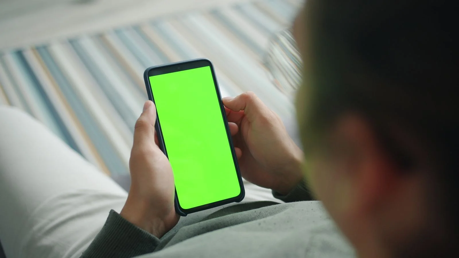 Person holding a phone displaying a screen, mid-review on a mobile app