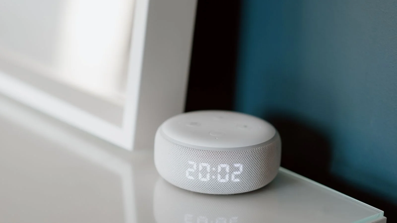 A smart speaker with a glowing display on a desk, ready to read a single spoken answer aloud