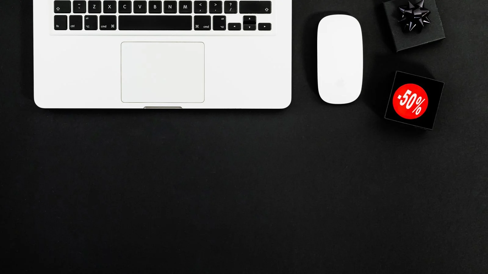 A minimalist flat lay of a laptop and items with visible sale tags
