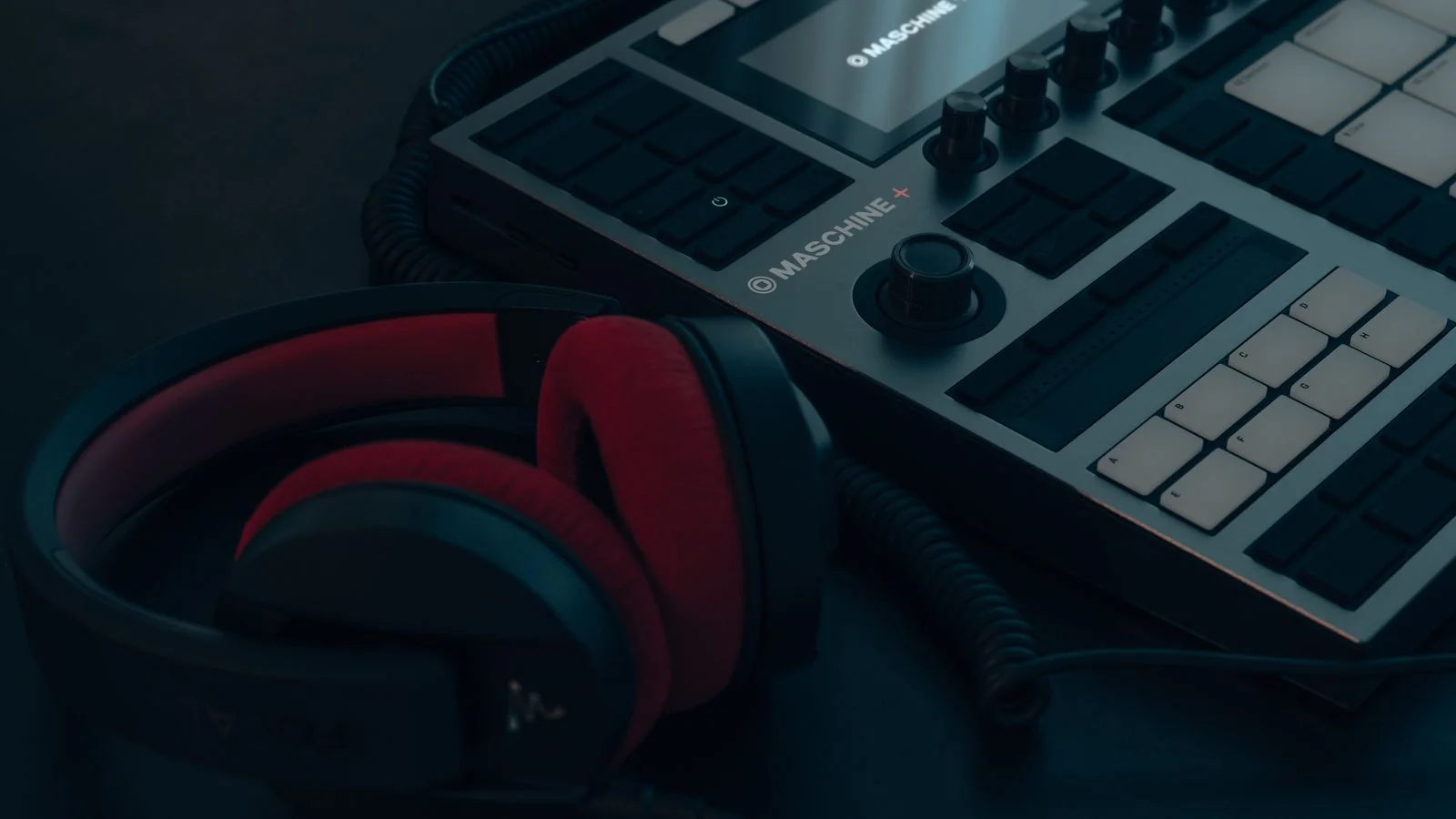 A drum machine and headphones on a work surface, the production side of a podcast few guests ever see