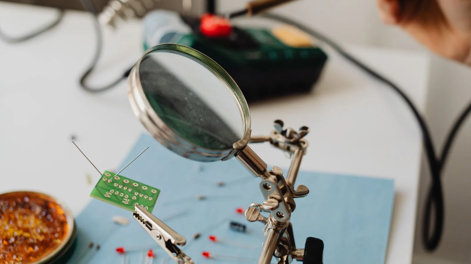 Scientist examining a circuit board under a magnifier, the level of detail a technical pitch has to survive