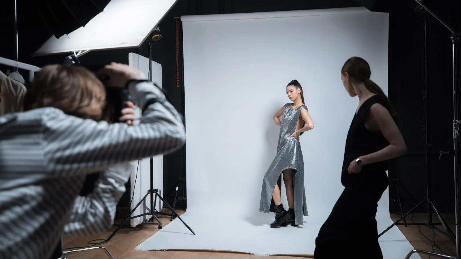 Photographer adjusting setup at a styled studio shoot, the working environment that glossy editors are visualizing while reading every feature pitch.