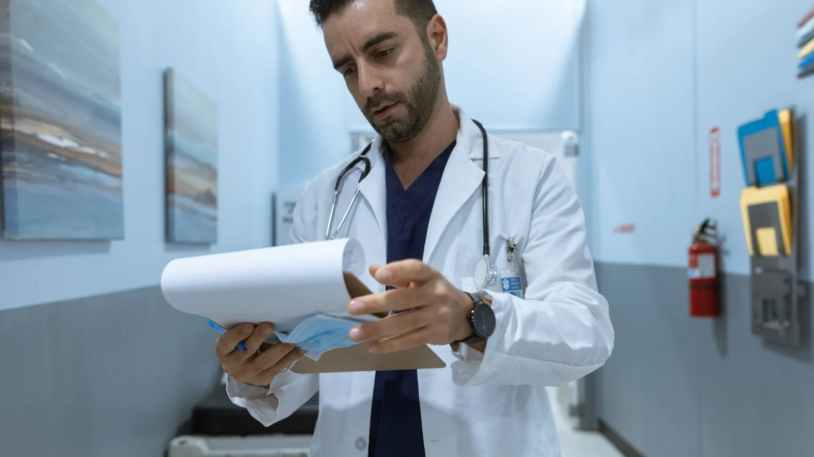 A doctor reviewing a medical chart in a hospital hallway, the verifiable expertise a pitch must put first