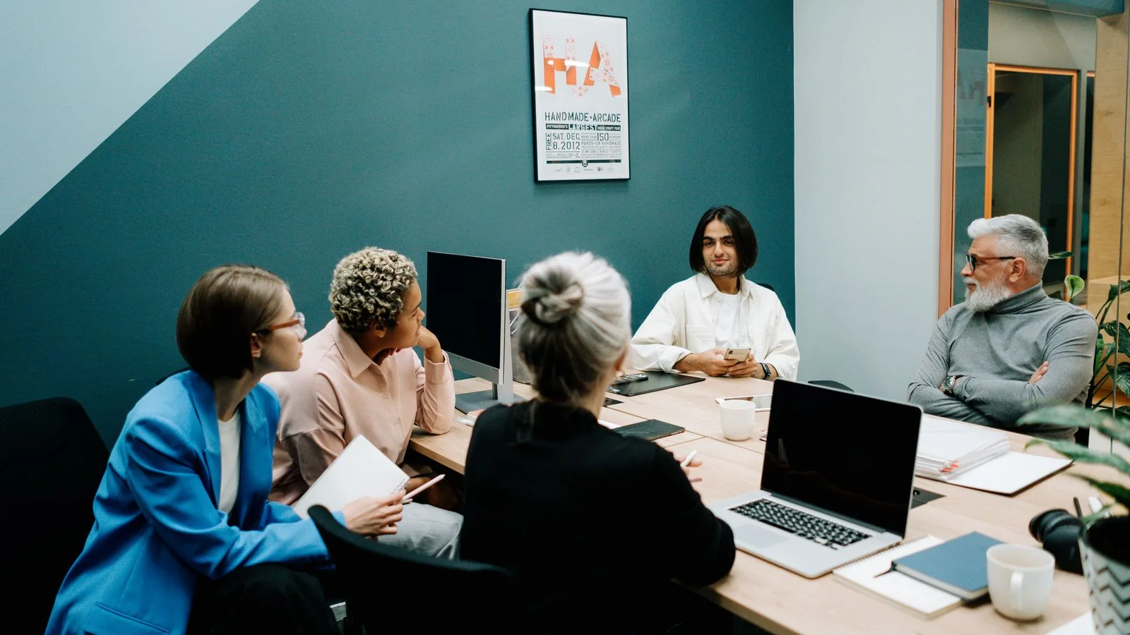 Team in a conference room working through a problem at a whiteboard table