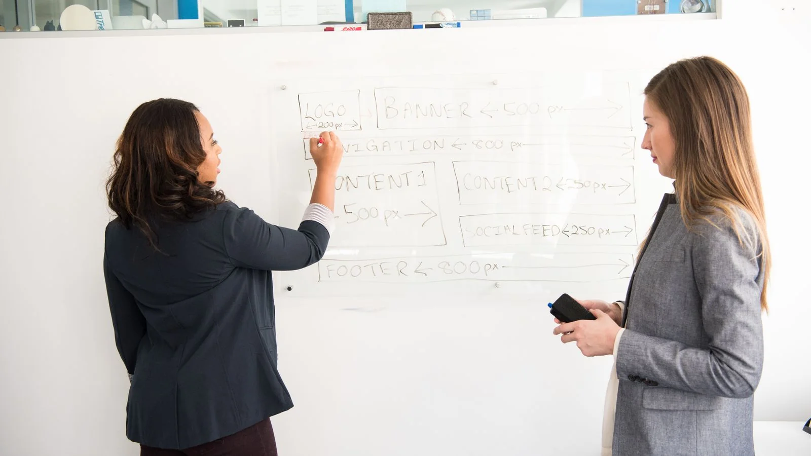 Two colleagues working through a presentation at a whiteboard, the focused, specific answers that win Perplexity source slots