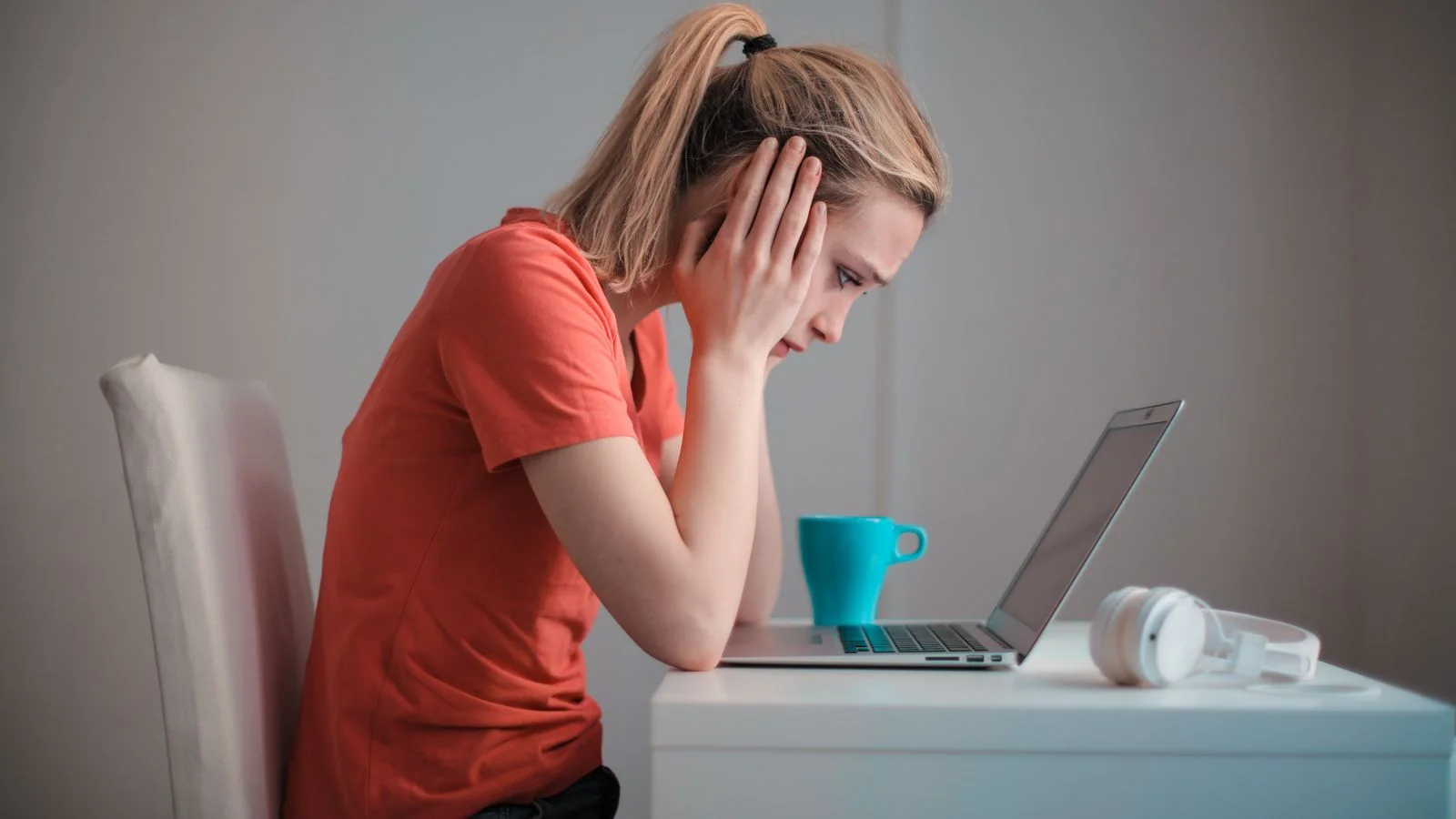 A worried person studying her laptop screen, reacting to an unwanted search result