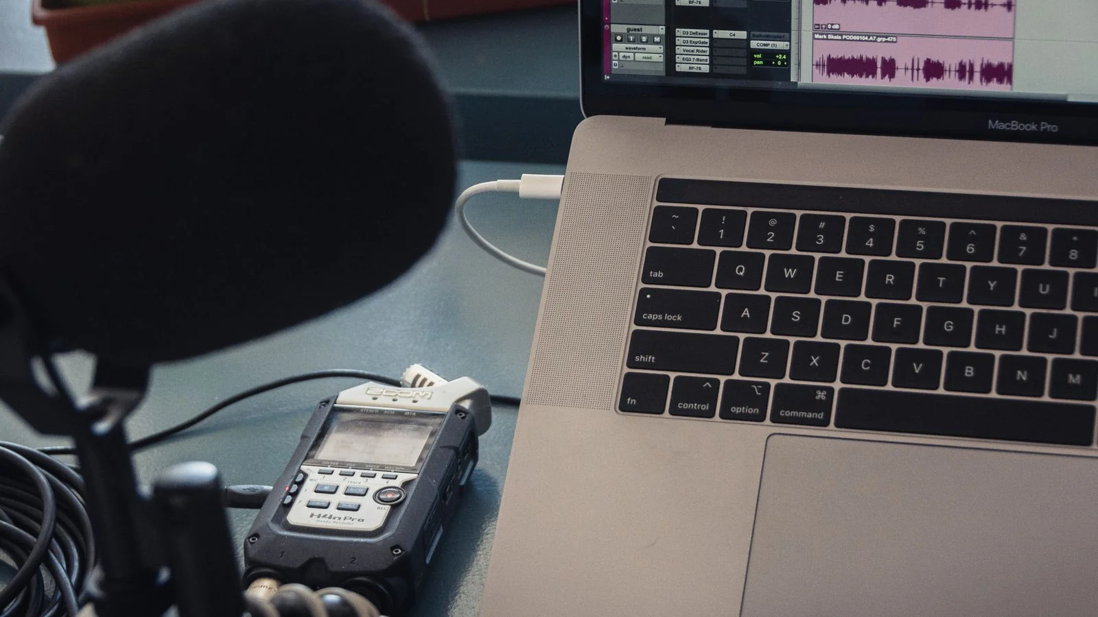 A microphone and laptop set up on a desk for recording a podcast segment about a company announcement