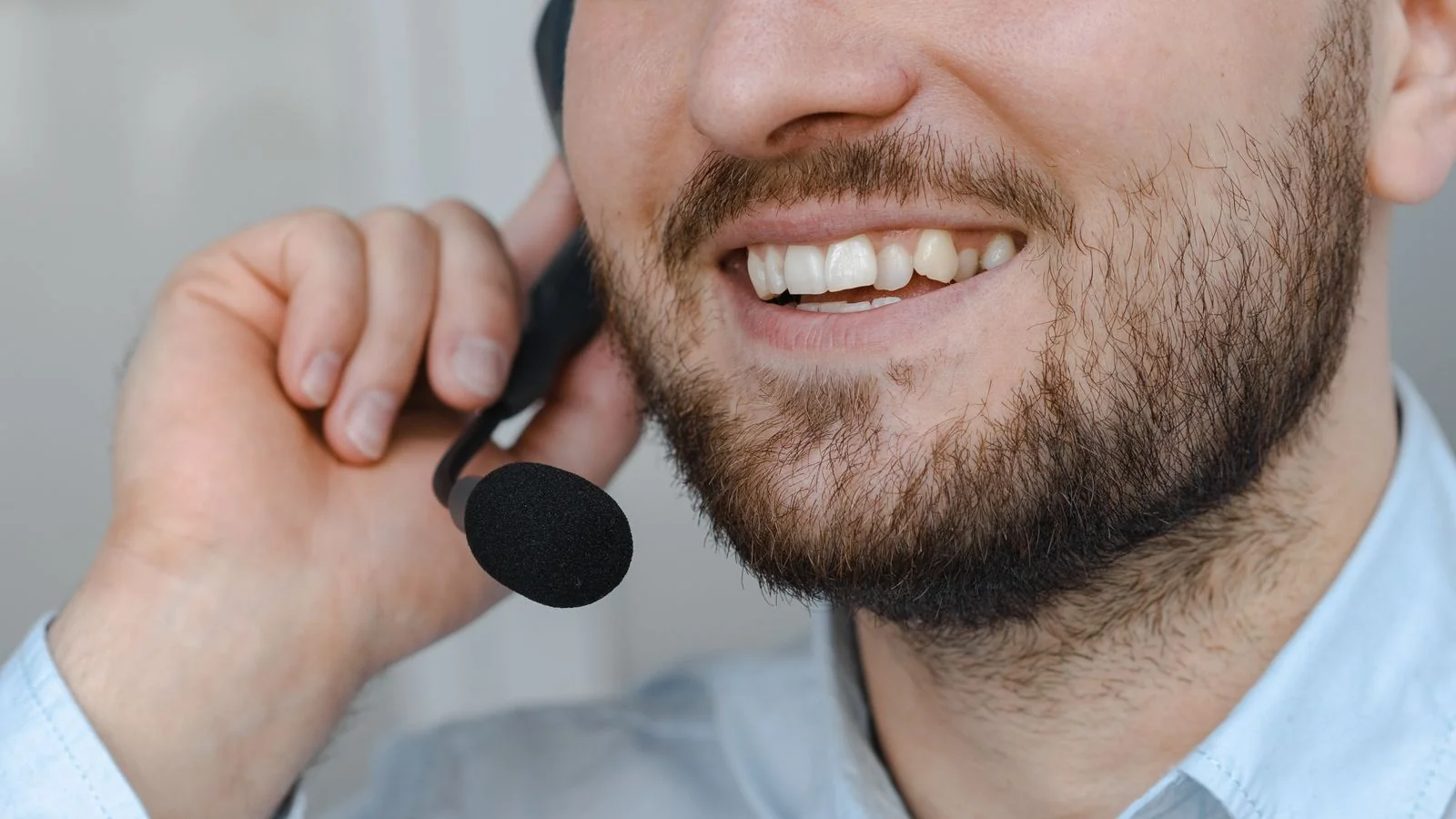 A customer support agent with a headset, focused on a measured reply rather than a quick defensive one