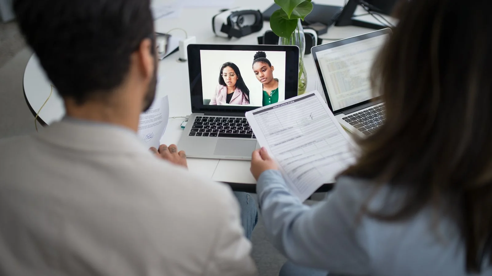 Two professionals on a virtual interview across laptops, the follow-up call a good reply earns