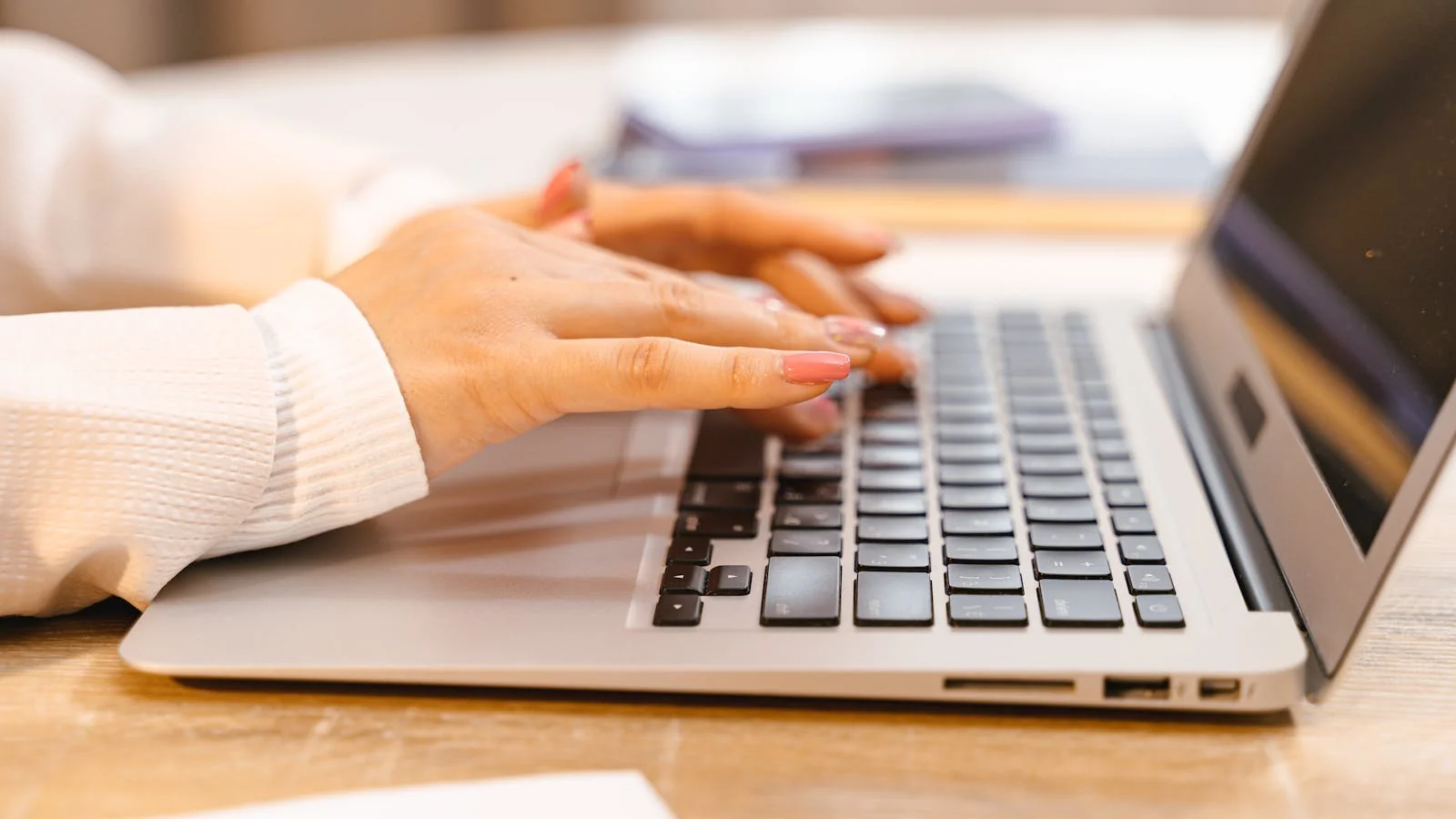 Hands typing a professional written response letter on a laptop with a coffee mug nearby for the BBB portal
