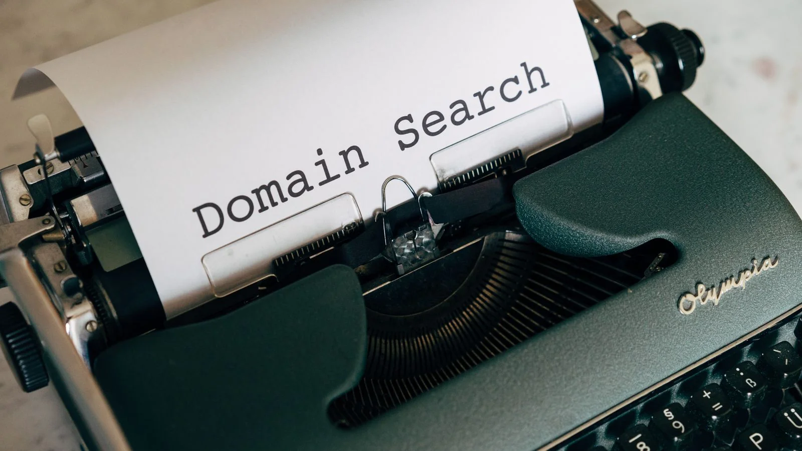 Typewriter with 'Domain Search' typed on paper, representing website property verification in Google Search Console