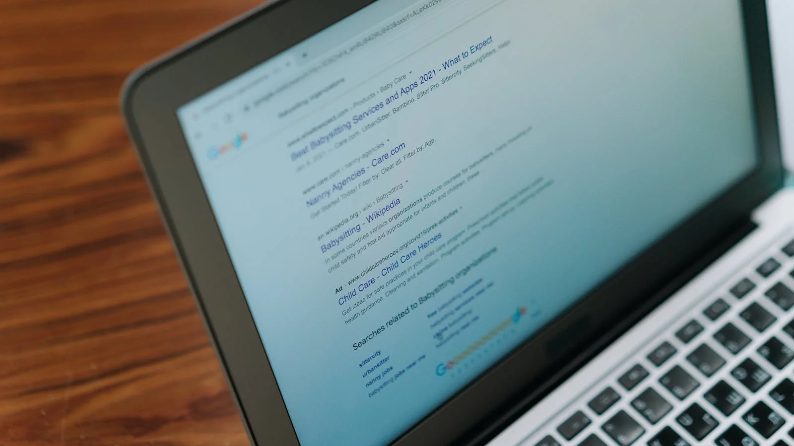 A laptop showing a search engine page with the cursor hovering over the search box, the entry point where schema markup gets read by the user as visual signal