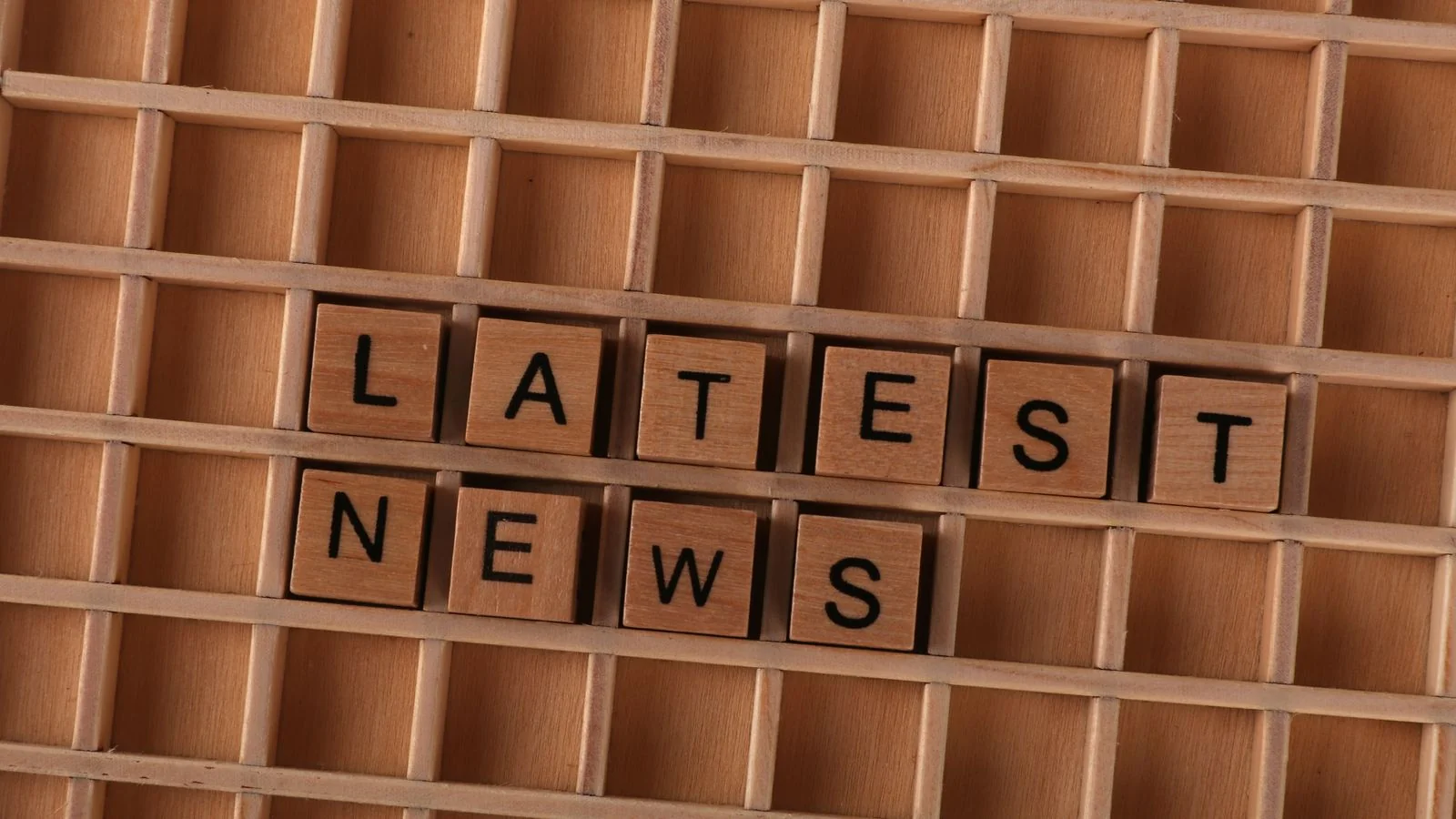 Wooden blocks spelling Latest News, the timely content that earns Perplexity's freshness premium on moving topics