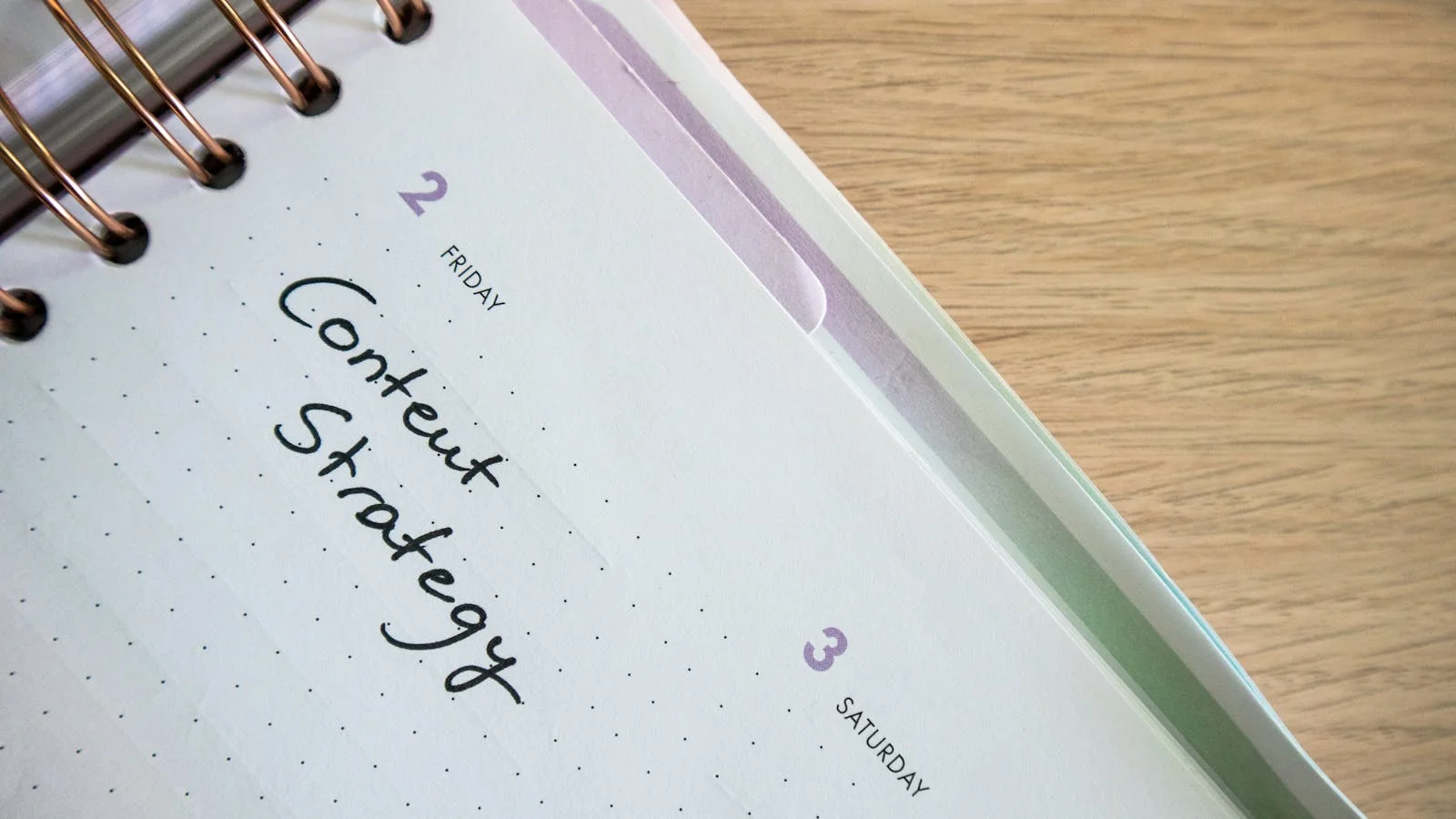 A planner notebook open to a 'Content Strategy' page with handwritten notes and a desktop keyboard visible at the edge of the desk.