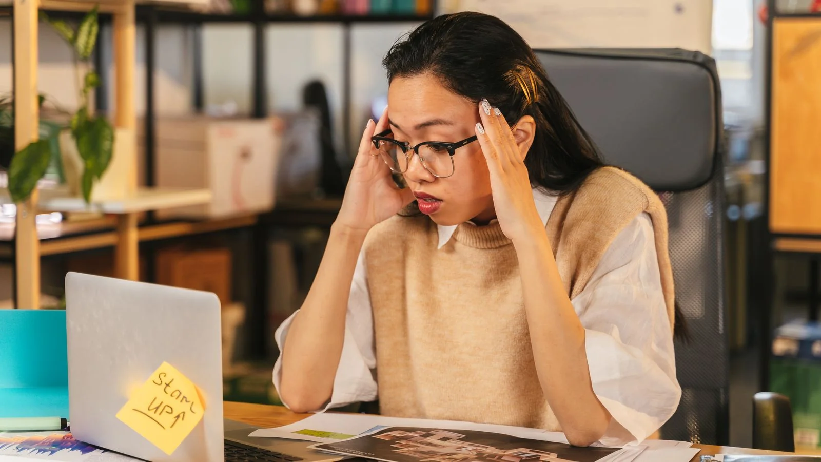 A person looking closely at a laptop while checking what appears under their name online