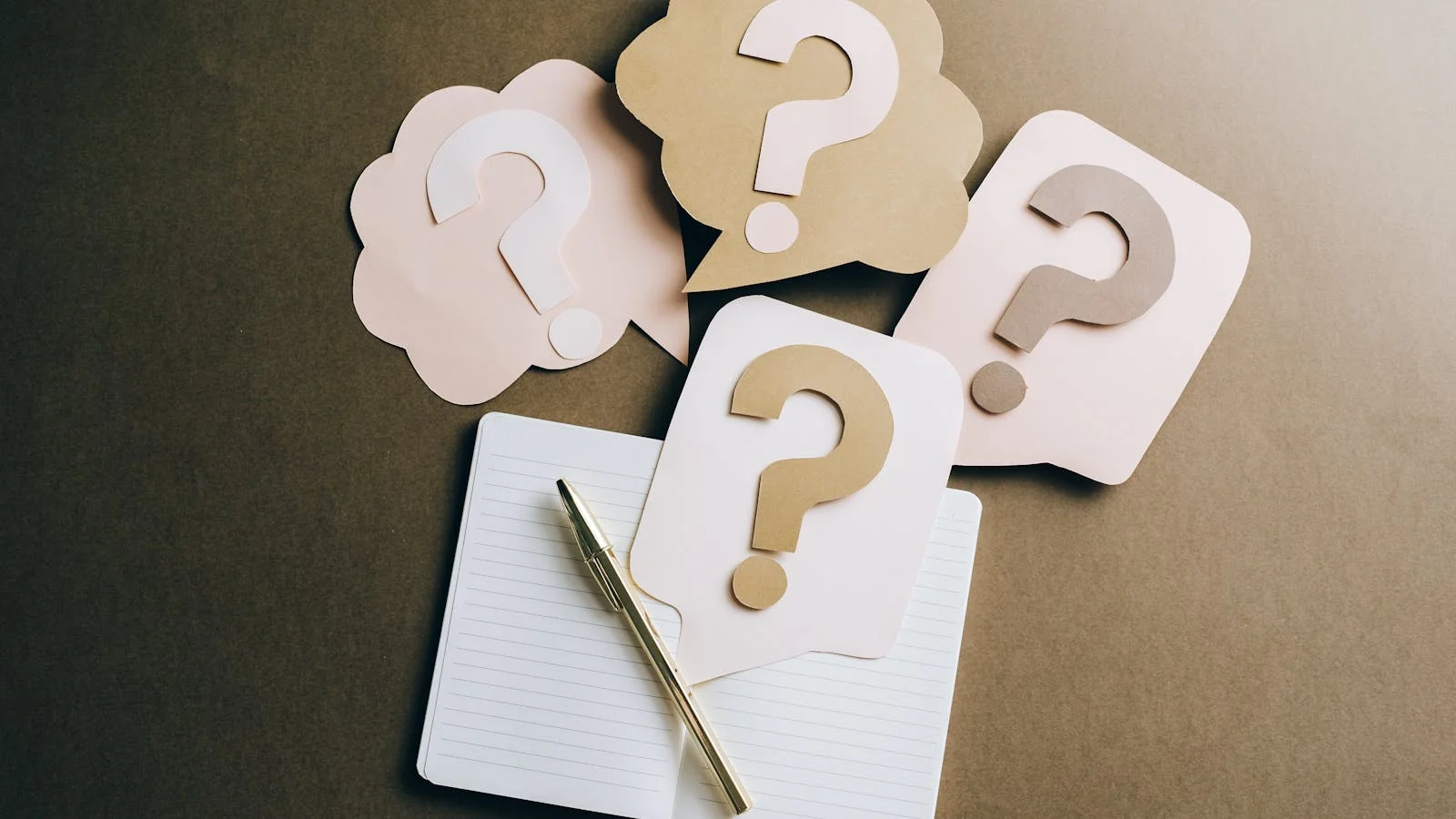 A green notepad with a hand-drawn question mark and a pencil, the kind of intent that drives every Quora session