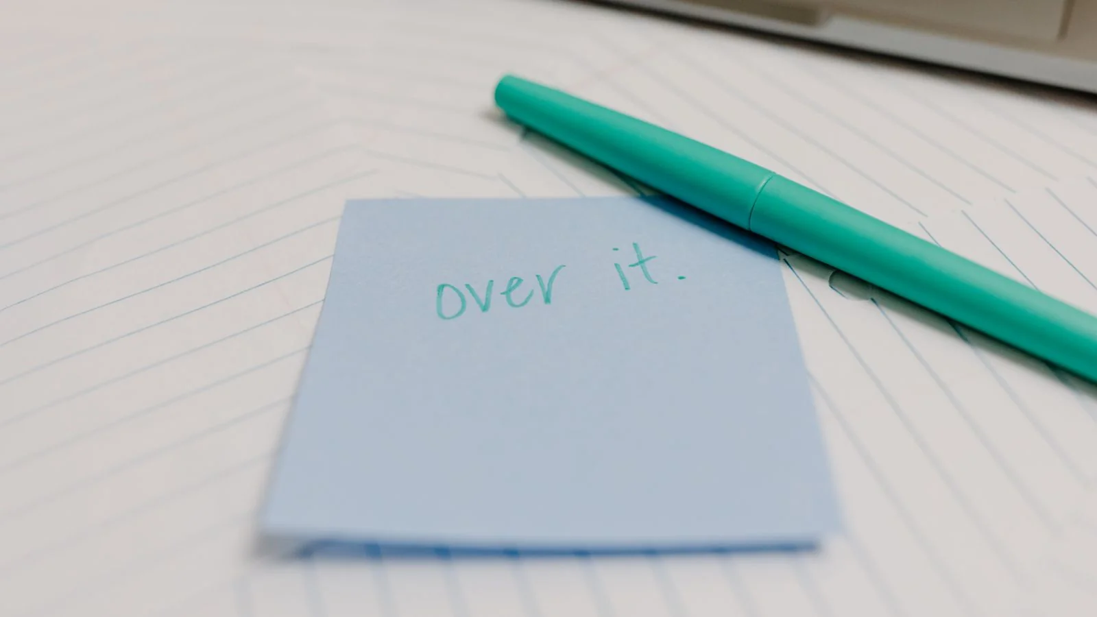 A blue sticky note reading over it beside a pen, roughly the feeling of a reporter opening their pitch folder
