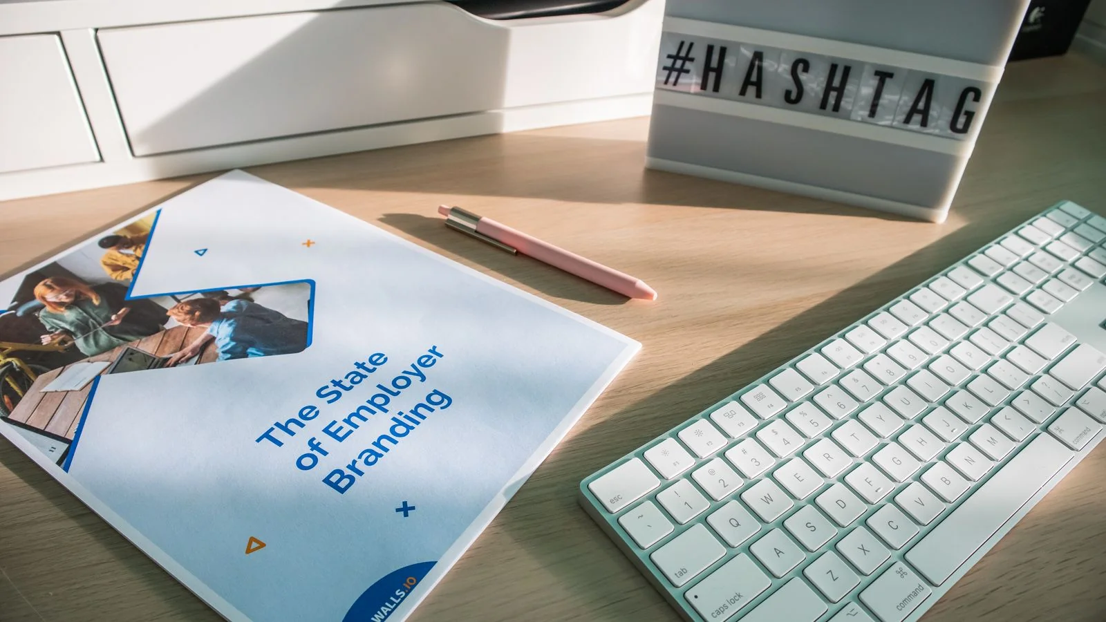 Desk workspace with a printed branding report and a hashtag sign, the modern life of a reused brand description