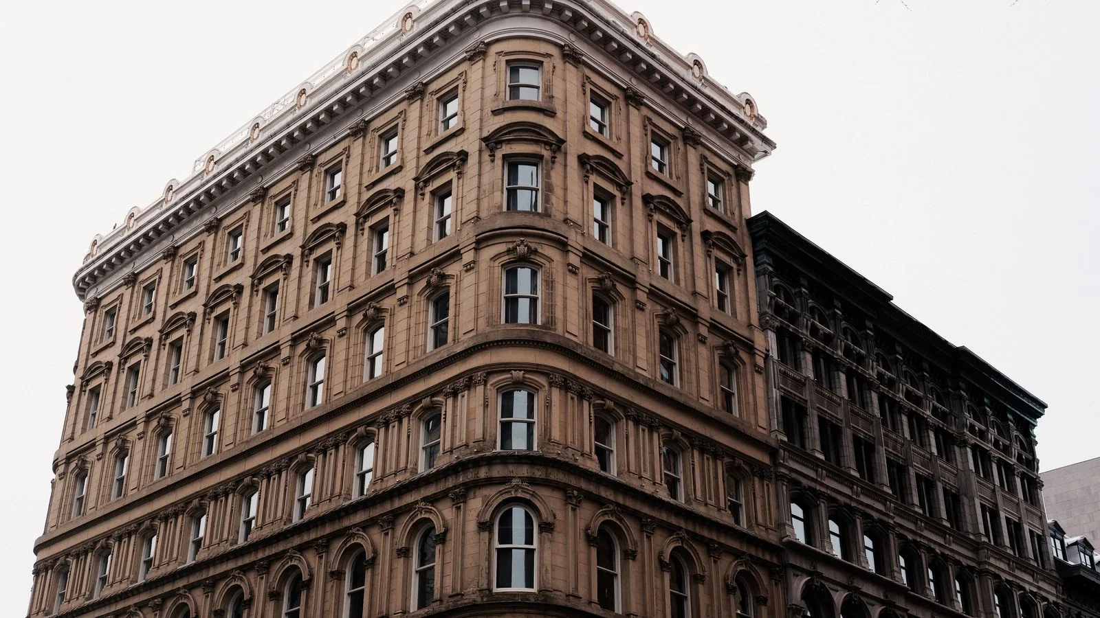 An older facade with arched windows and detailed stonework, the documented history most owners never look up.