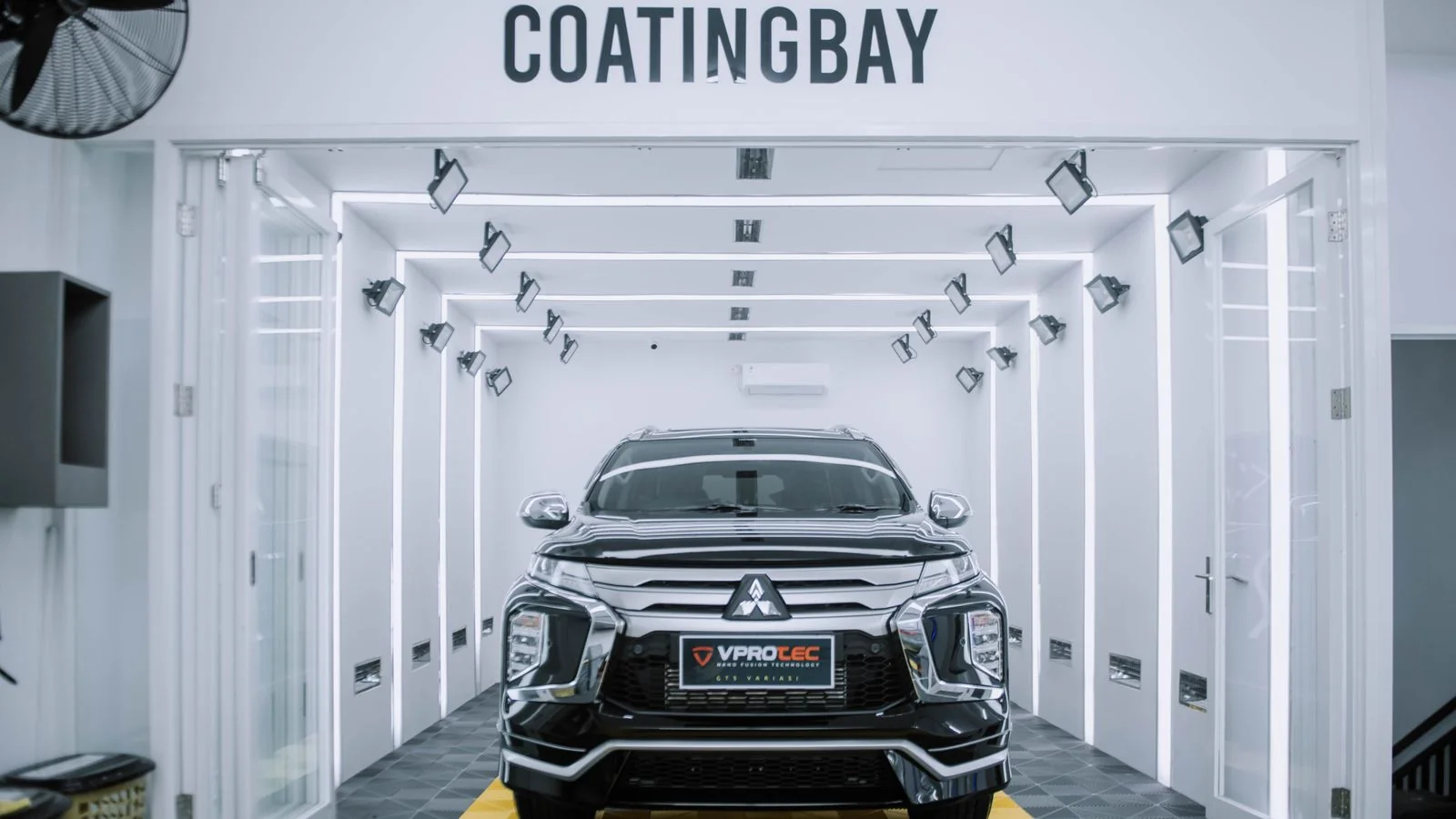 A clean SUV parked inside a modern automotive coating and detailing facility.