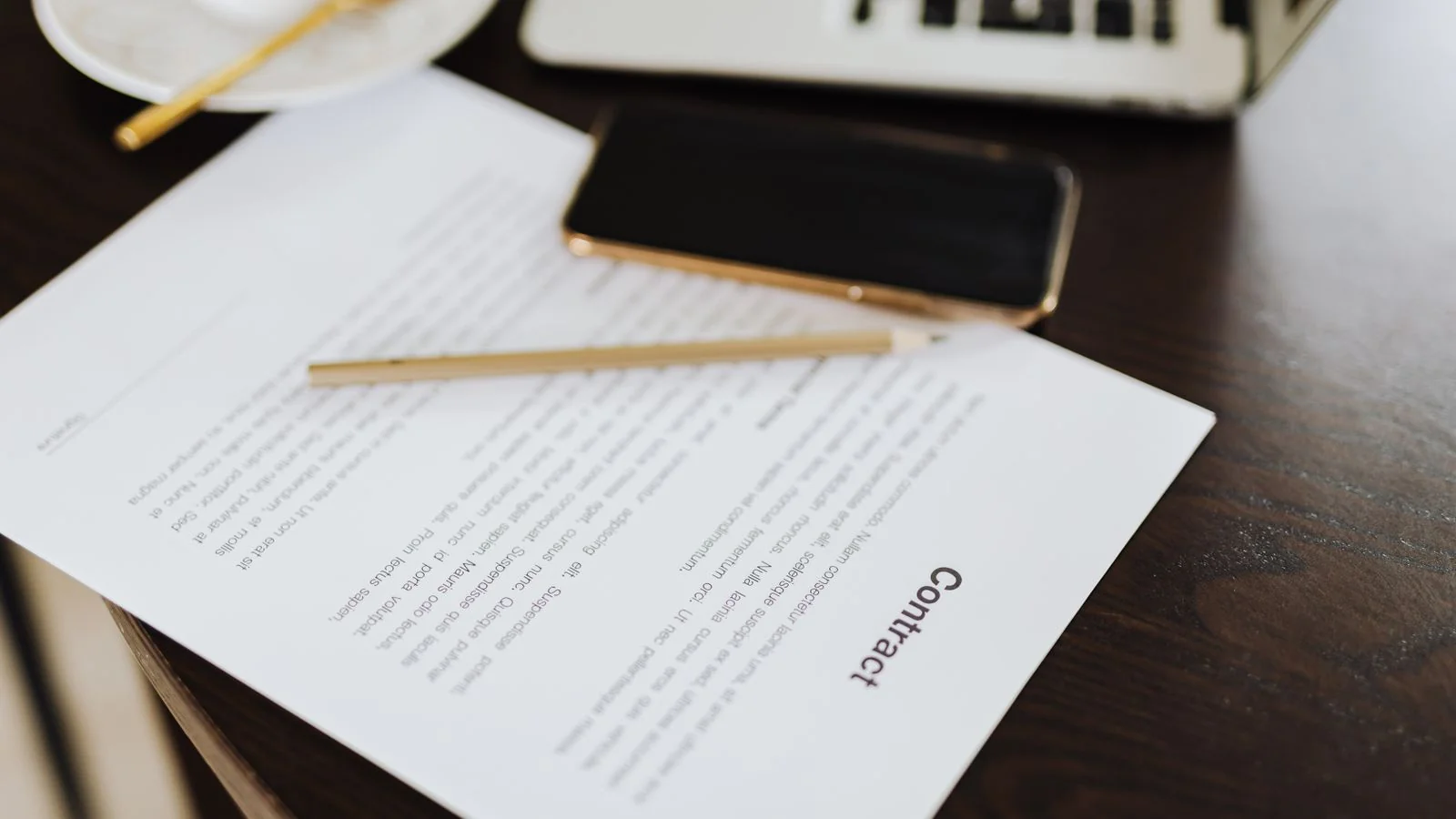 A laptop showing a document being written on a desk.