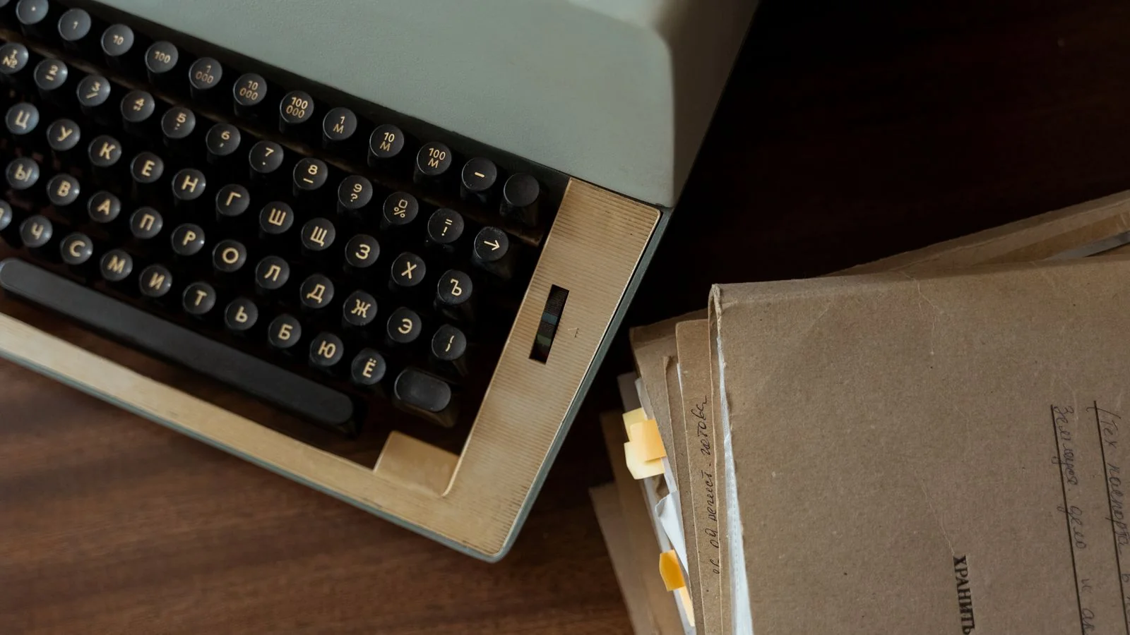 A vintage typewriter beside stacked documents, a reminder to write the release like a reporter, not an advertiser.