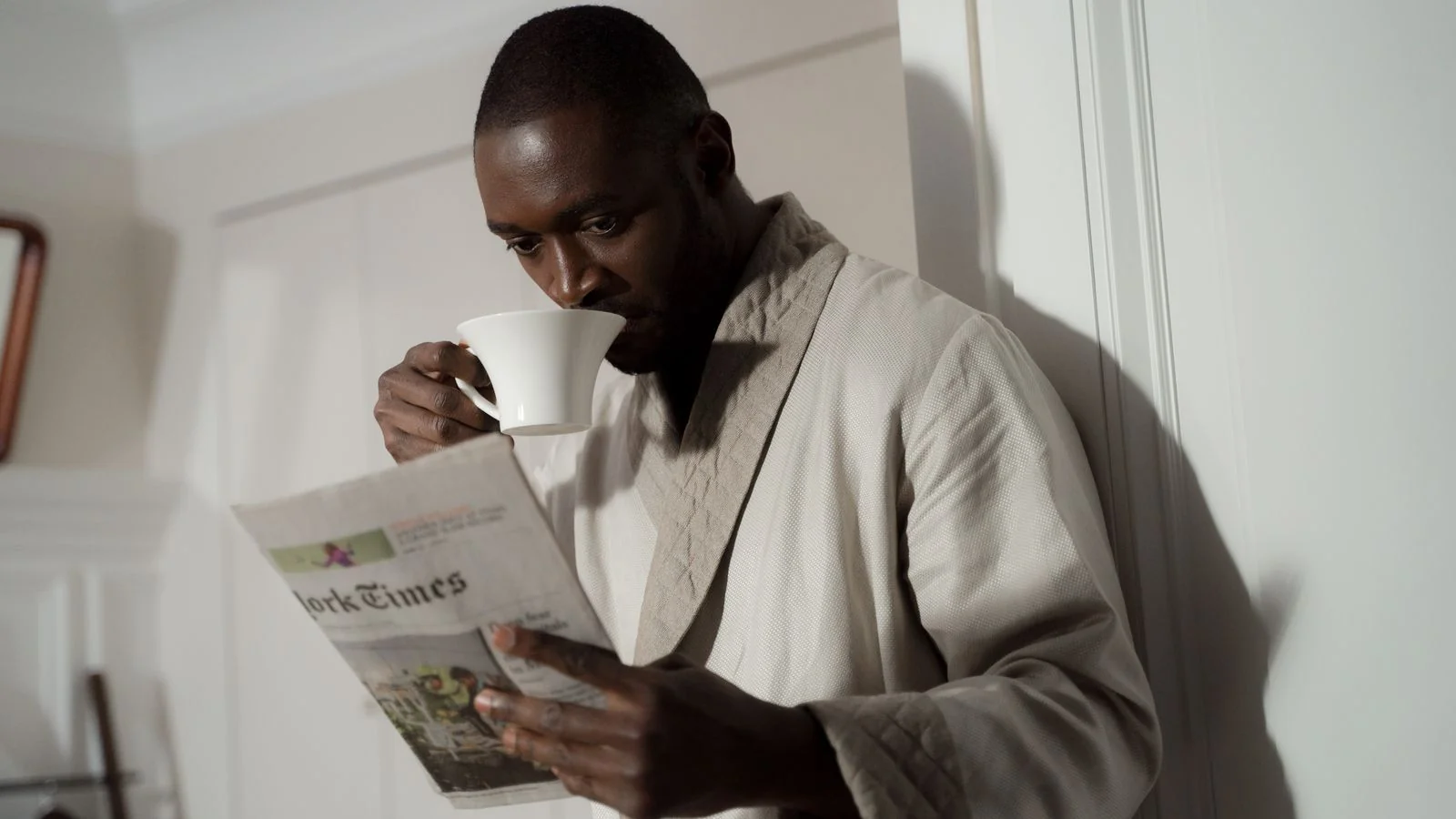 Man in a bathrobe reading the morning paper over coffee, the audience a home editor writes for.