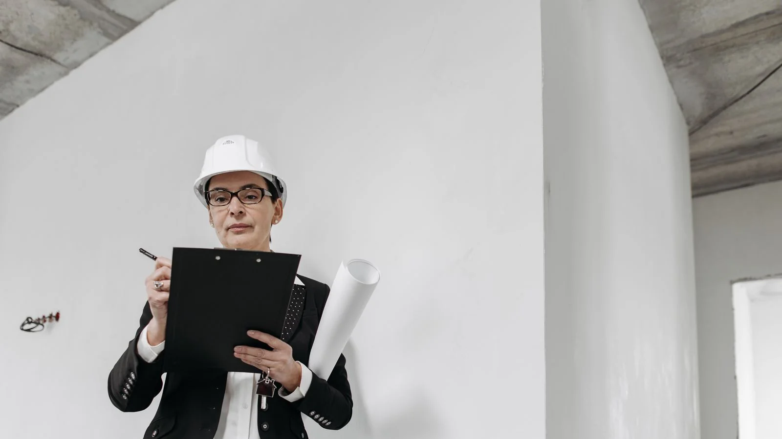 Contractor in a hard hat writing notes on a clipboard, drafting the headline before choosing the project.