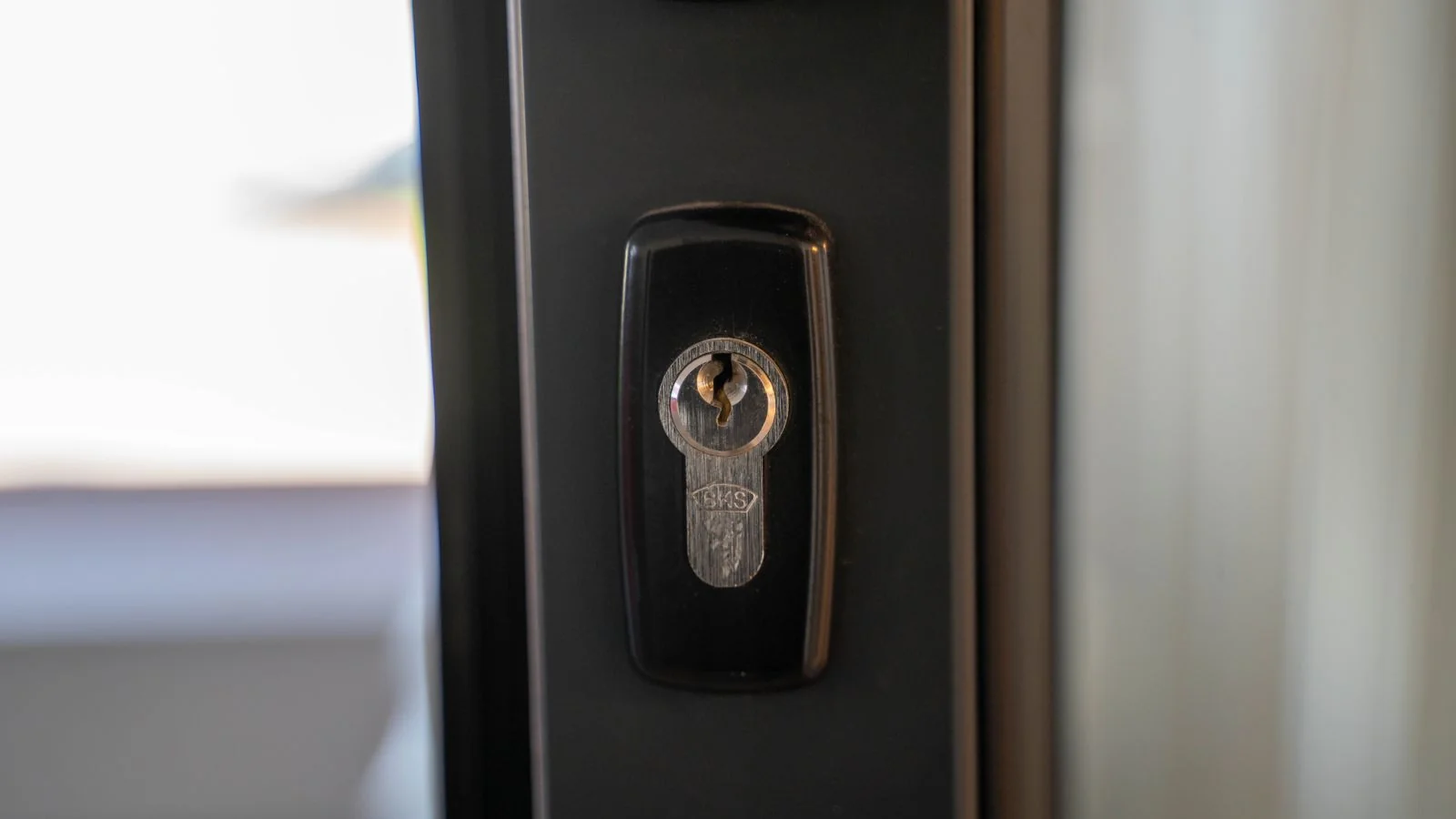 Close-up of a steel keyhole on a residential door, emphasizing home security.