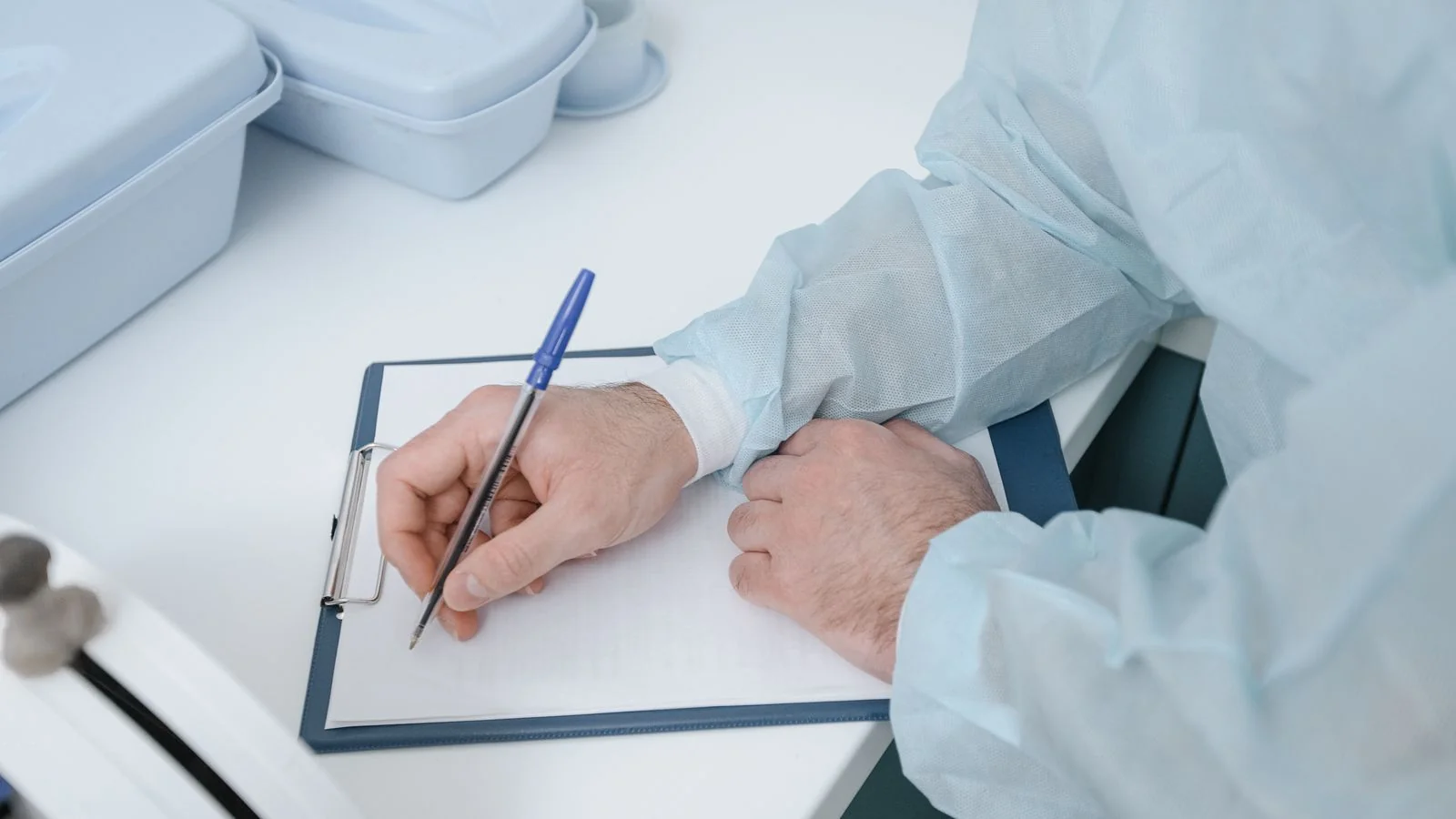 A practitioner writing up notes on a clipboard, the record-keeping that produces the numbers a release needs