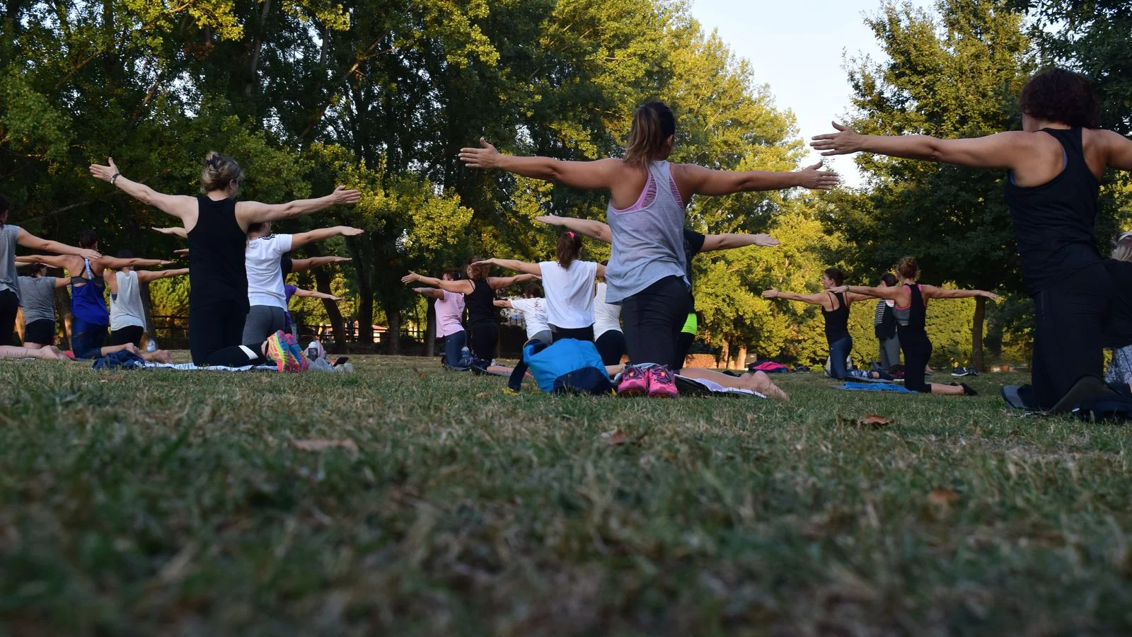 A group fitness class training outdoors in a park