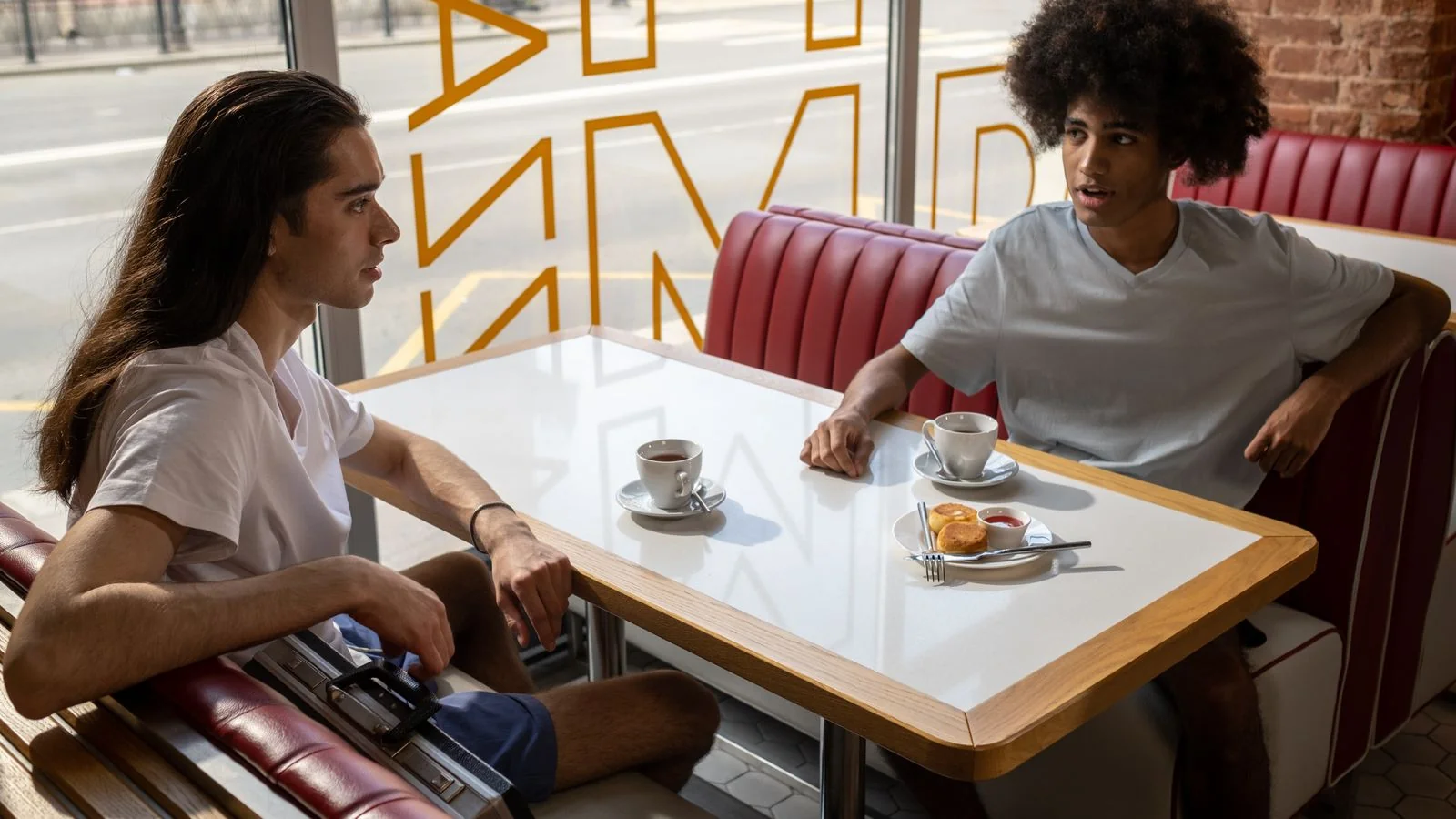 Two people in conversation across a small cafe table