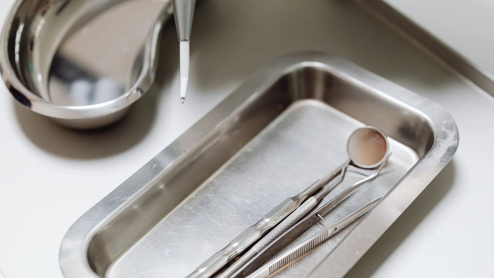 Close-up of sterile instruments laid out on a clean metal tray, the sanitation standard worth putting on the record