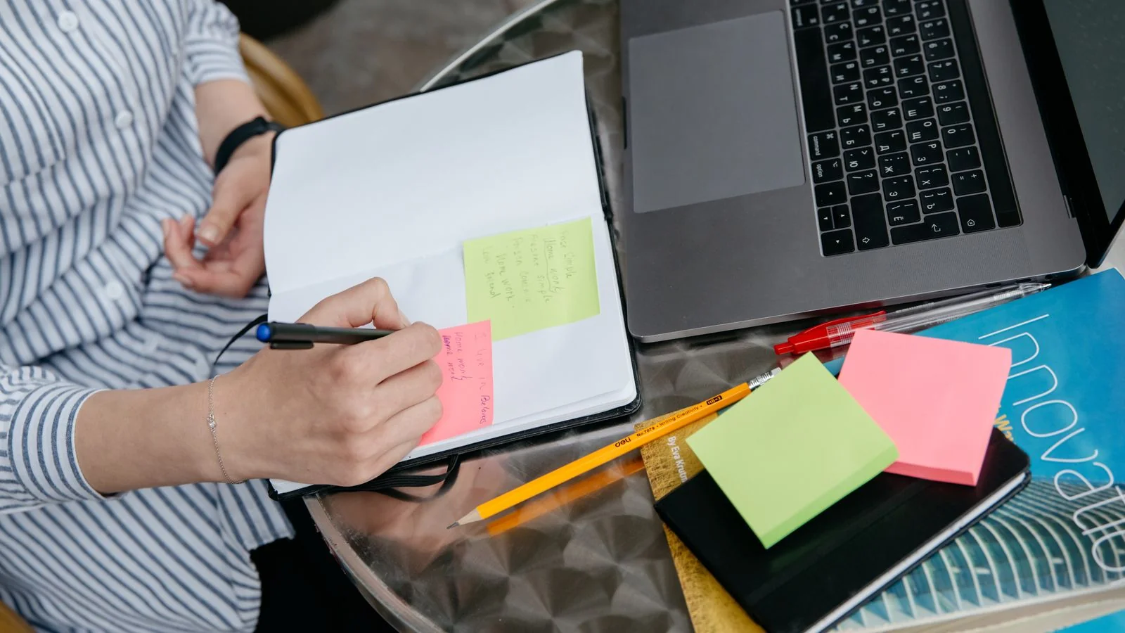 Notebook and laptop on a desk where a writer maps out a post's structure before drafting