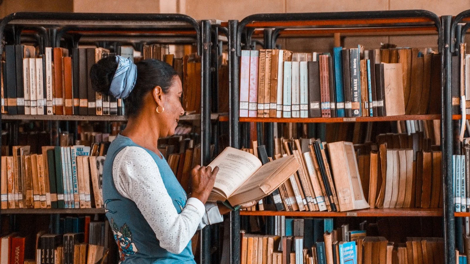 A reader between library shelves with a focused study expression, the kind of detail-driven mind that trusts content backed by real citations