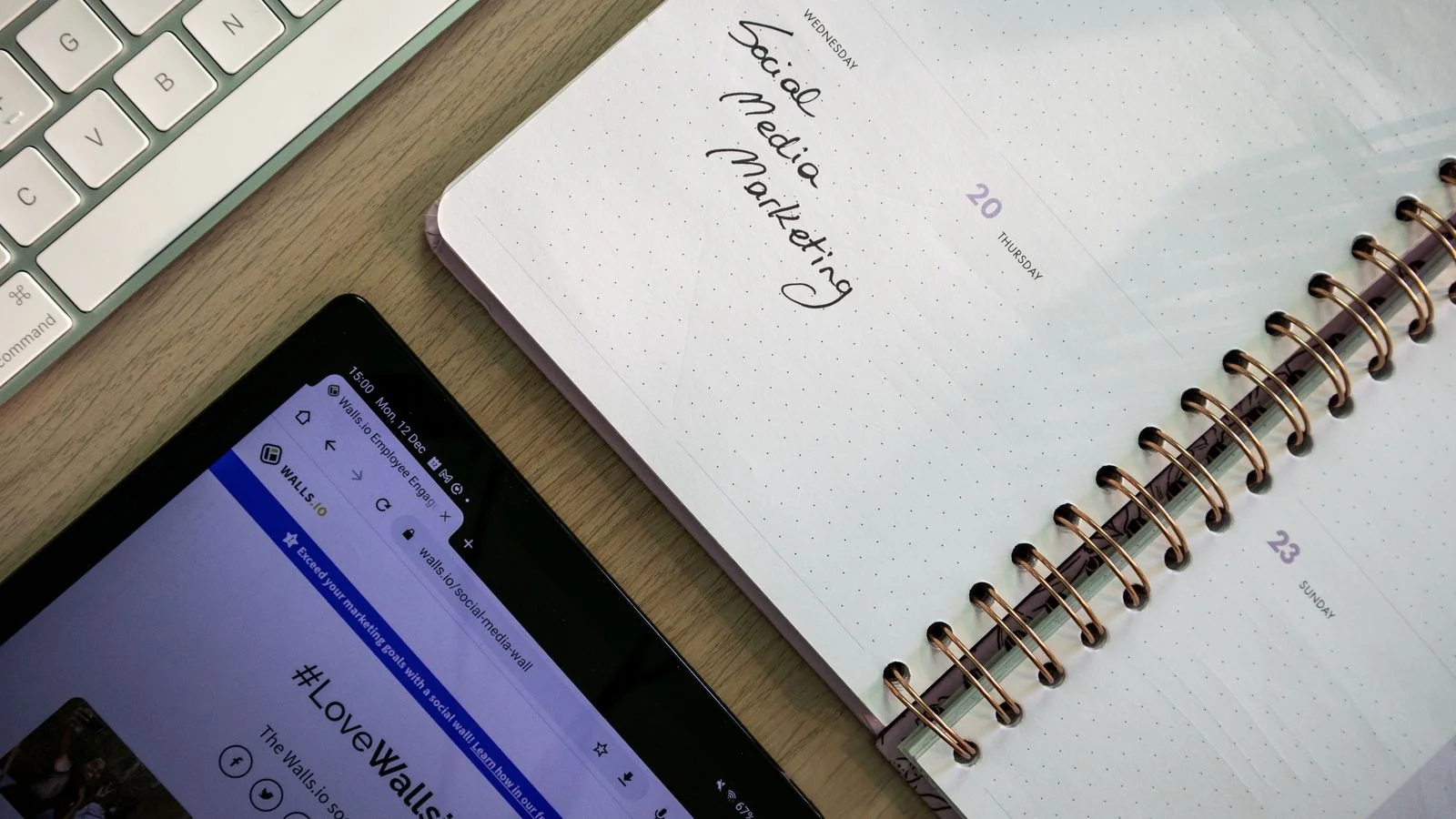 Top view of a notebook, tablet and keyboard used for marketing content planning
