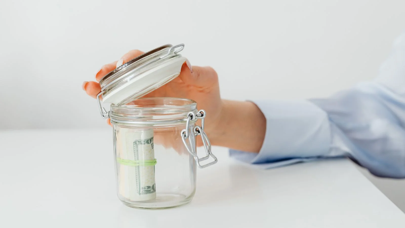 Coins going into a savings jar, the household decisions Kiplinger readers are weighing