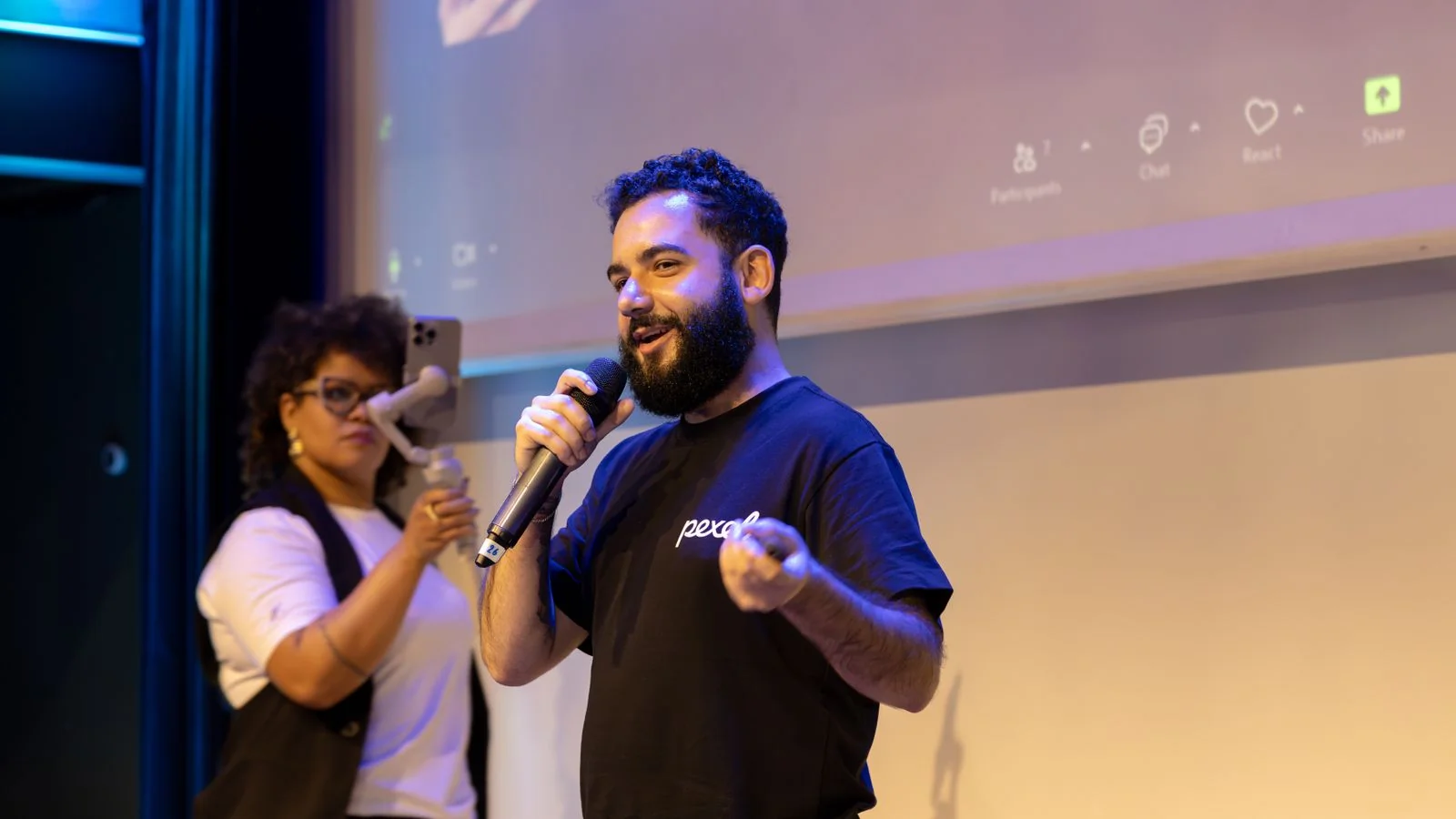 Speaker with a microphone on stage while an audience member records, the SMX route to a byline
