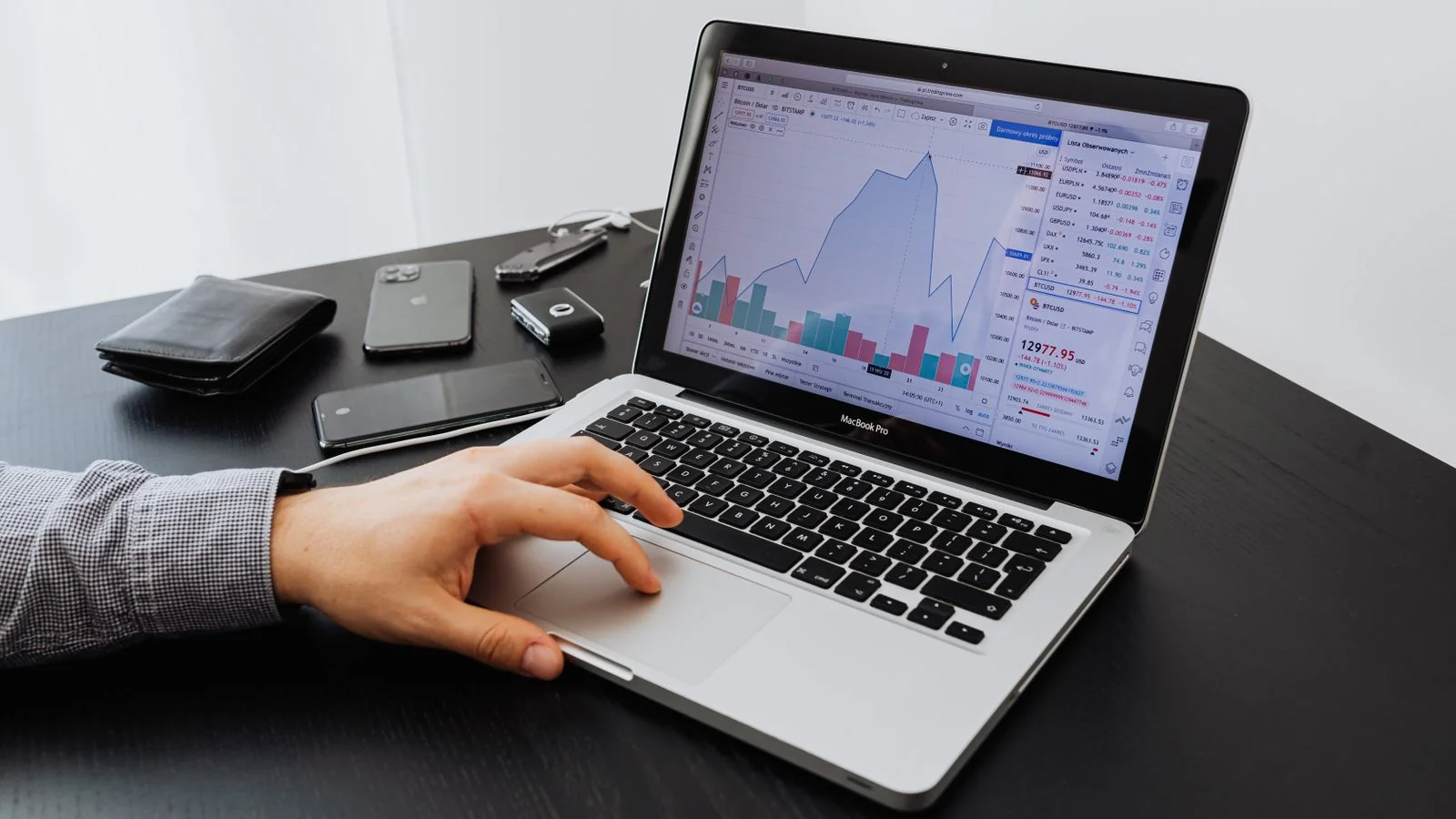 Analyst reviewing stock market data on a laptop at a desk in the early stages of research